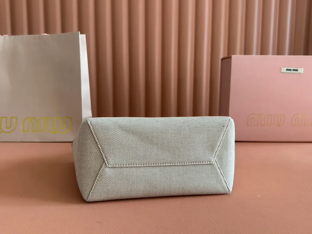p1360. 💋💋💋【Full set of packaging at the counter】Miu's new product Isetan limited edition tote bag, promoted by the official website, absolutely popular this year🔥 style, top imported calfskin, the leather surface is delicate, smooth and soft, the superior leather texture is high-end, the bag body is soft but not collapsed, small size The design is more refined, and the temperament is casual and lazy. It will turn heads every day when you carry it on the street. It has hand-stitched leather logo, brand new linen lining, two zippered pockets, long adjustable leather shoulder strap, model 5BA288, size 22X 14X11Cm.