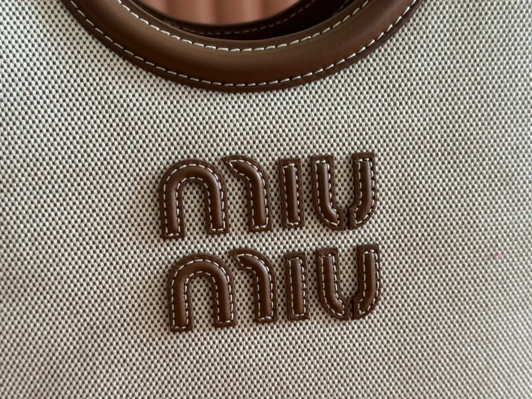 p1360. 💋💋💋【Full set of packaging at the counter】Miu's new product Isetan limited edition tote bag, promoted by the official website, absolutely popular this year🔥 style, top imported calfskin, the leather surface is delicate, smooth and soft, the superior leather texture is high-end, the bag body is soft but not collapsed, small size The design is more refined, and the temperament is casual and lazy. It will turn heads every day when you carry it on the street. It has hand-stitched leather logo, brand new linen lining, two zippered pockets, long adjustable leather shoulder strap, model 5BA288, size 22X 14X11Cm.