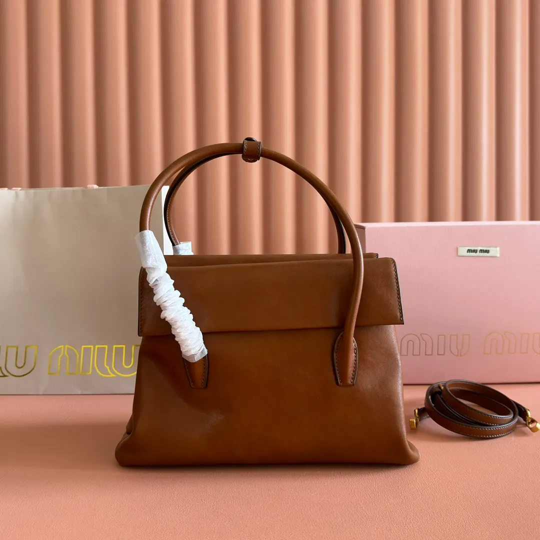 p1700💋💋💋【Configuring full counter package】Vintage cow leather Solitaire medium handbag: 5BA302 Structured lines and exquisite details define this handbag, inspired by MiuMiu's 2006 archives. An elegant style that combines classic and experimental is enhanced by the iconic logo on the front and a shiny finish. ·With handle ●With removable decoration. Comes with sliding and removable shoulder strap. Minimum length: 110 cm - Maximum length: 120 cm - Minimum drop: 50 cm - Maximum drop: 55 cm · Front and back pockets · Gold hardware · Zippered pockets and patch pockets ● Lettering logo on the front Width: 28 cm, Height: 19.5 cm, Length: 11 cm