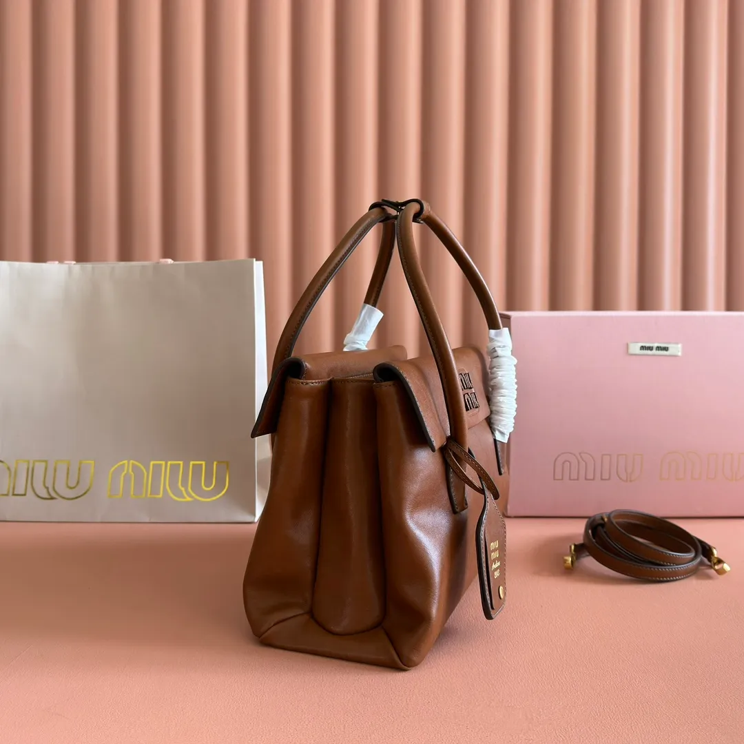 p1700💋💋💋【Configuring full counter package】Vintage cow leather Solitaire medium handbag: 5BA302 Structured lines and exquisite details define this handbag, inspired by MiuMiu's 2006 archives. An elegant style that combines classic and experimental is enhanced by the iconic logo on the front and a shiny finish. ·With handle ●With removable decoration. Comes with sliding and removable shoulder strap. Minimum length: 110 cm - Maximum length: 120 cm - Minimum drop: 50 cm - Maximum drop: 55 cm · Front and back pockets · Gold hardware · Zippered pockets and patch pockets ● Lettering logo on the front Width: 28 cm, Height: 19.5 cm, Length: 11 cm
