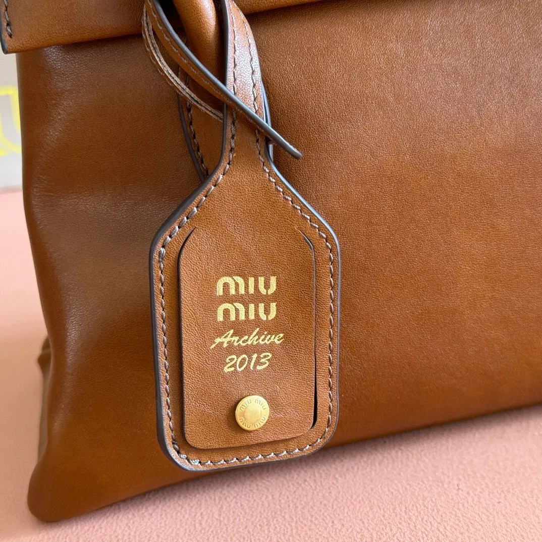 p1700💋💋💋【Configuring full counter package】Vintage cow leather Solitaire medium handbag: 5BA302 Structured lines and exquisite details define this handbag, inspired by MiuMiu's 2006 archives. An elegant style that combines classic and experimental is enhanced by the iconic logo on the front and a shiny finish. ·With handle ●With removable decoration. Comes with sliding and removable shoulder strap. Minimum length: 110 cm - Maximum length: 120 cm - Minimum drop: 50 cm - Maximum drop: 55 cm · Front and back pockets · Gold hardware · Zippered pockets and patch pockets ● Lettering logo on the front Width: 28 cm, Height: 19.5 cm, Length: 11 cm