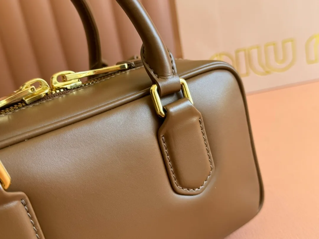 p1640💋💋💋【Full set of packaging at the counter】MIU MIU Miu Miu Caramel Bowling Upper Body Effect! Miu Miu Women's Arcadia Cowhide Handbag Crossbody Bag👝Lightly padded design makes the handbag look fuller, showing a cosmopolitan style. The letter logo, which echoes the finish of the metal hardware, straddles the line between function and decoration, giving this handbag a unique aesthetic and classic feel. Size: 22✖️10.5✖️7.5cm Style number: 5bb142 brown