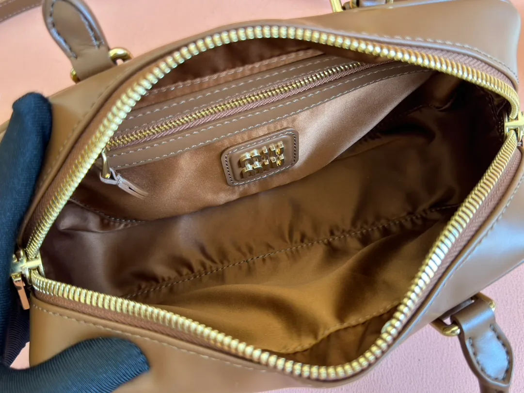 p1640💋💋💋【Full set of packaging at the counter】MIU MIU Miu Miu Caramel Bowling Upper Body Effect! Miu Miu Women's Arcadia Cowhide Handbag Crossbody Bag👝Lightly padded design makes the handbag look fuller, showing a cosmopolitan style. The letter logo, which echoes the finish of the metal hardware, straddles the line between function and decoration, giving this handbag a unique aesthetic and classic feel. Size: 22✖️10.5✖️7.5cm Style number: 5bb142 brown