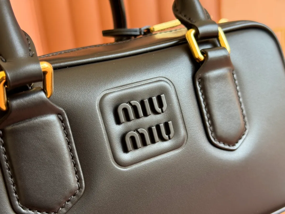 p1640💋💋💋【Full set of packaging at the counter】MIU MIU Miu Miu Caramel Bowling Upper Body Effect! Miu Miu Women's Arcadia Cowhide Handbag Crossbody Bag👝Lightly padded design makes the handbag look fuller, showing a cosmopolitan style. The letter logo, which echoes the finish of the metal hardware, straddles the line between function and decoration, giving this handbag a unique aesthetic and classic feel. Size: 22✖️10.5✖️7.5cm Style number: 5bb142g color