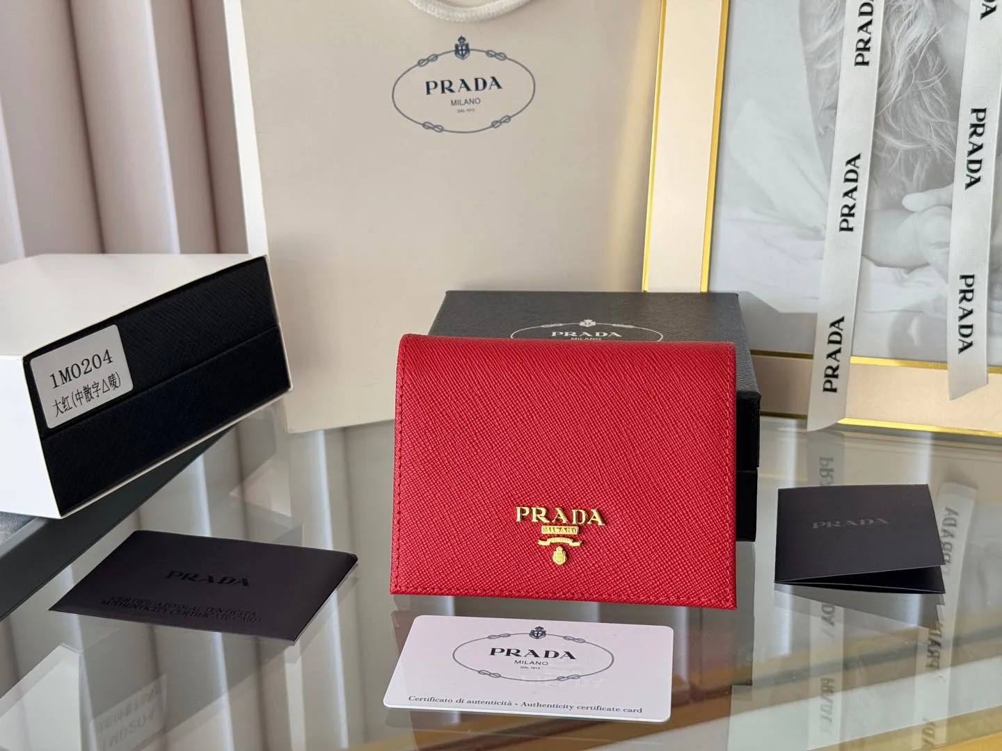 Prada women's two-fold short clip, with coin pocket and coin pocket. Model 1M0204, cross-grain cowhide. Size: 11.2x9.5cm. Simple and practical to enhance personal taste.