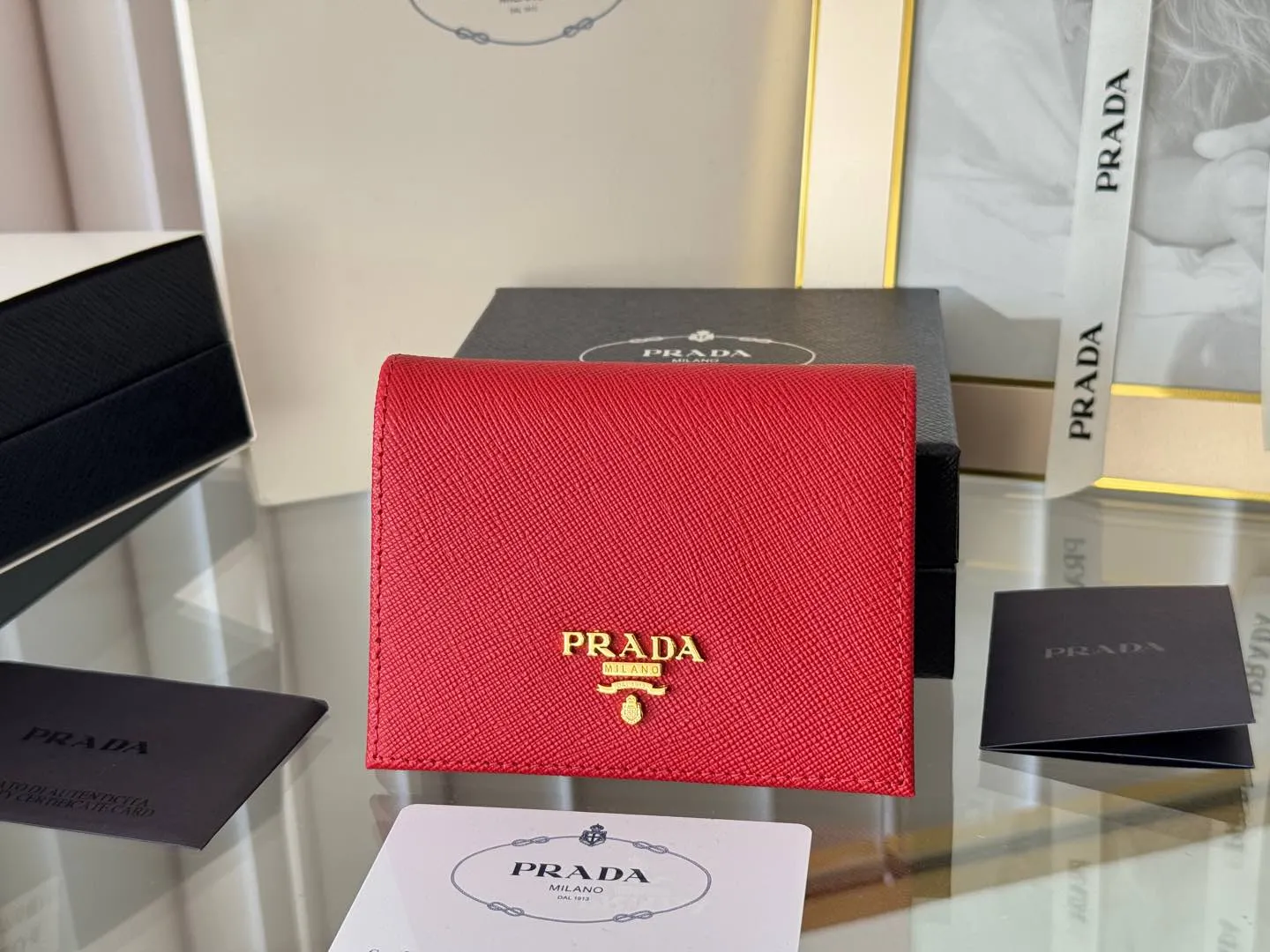 Prada women's two-fold short clip, with coin pocket and coin pocket. Model 1M0204, cross-grain cowhide. Size: 11.2x9.5cm. Simple and practical to enhance personal taste.