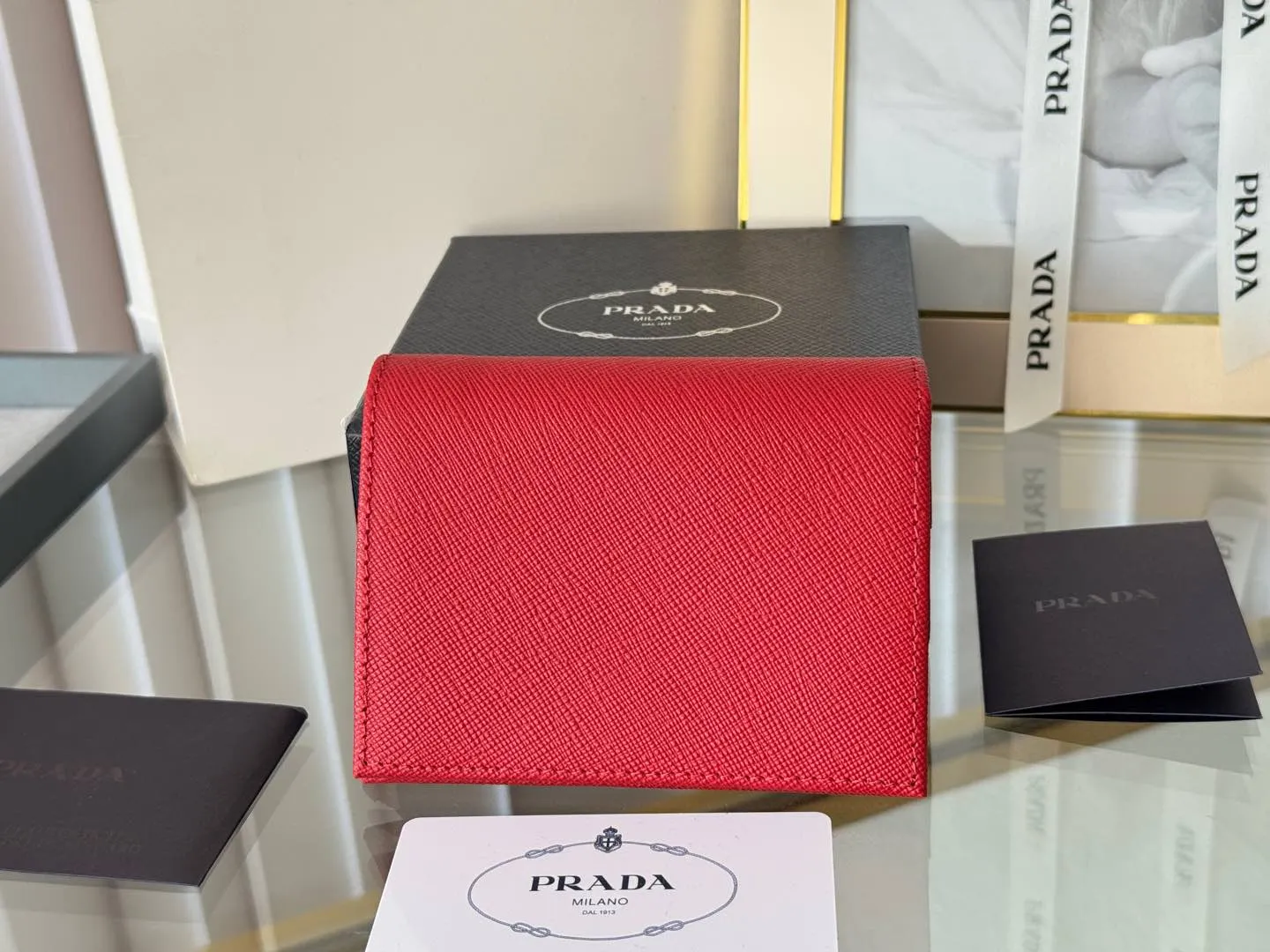 Prada women's two-fold short clip, with coin pocket and coin pocket. Model 1M0204, cross-grain cowhide. Size: 11.2x9.5cm. Simple and practical to enhance personal taste.