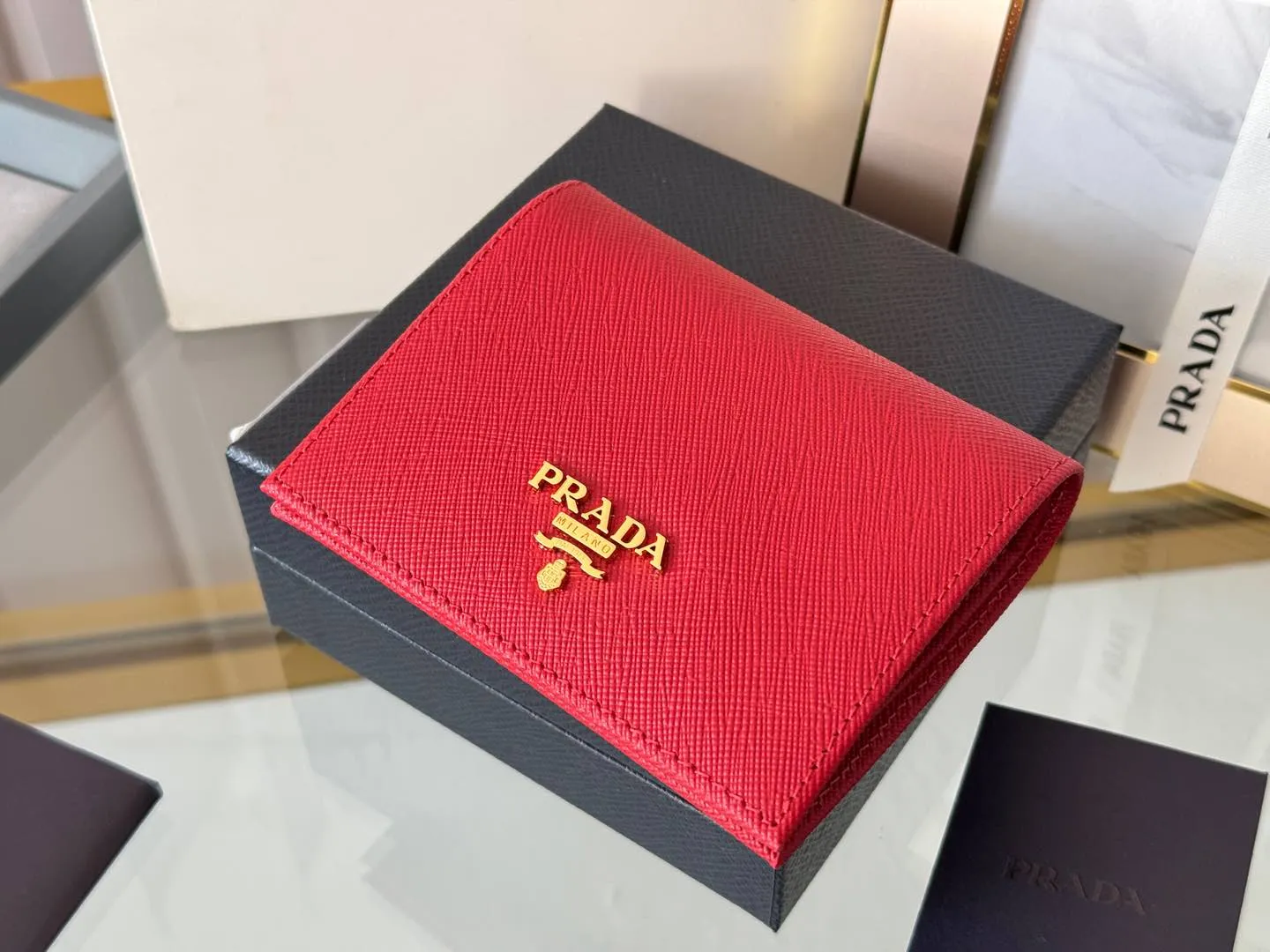 Prada women's two-fold short clip, with coin pocket and coin pocket. Model 1M0204, cross-grain cowhide. Size: 11.2x9.5cm. Simple and practical to enhance personal taste.