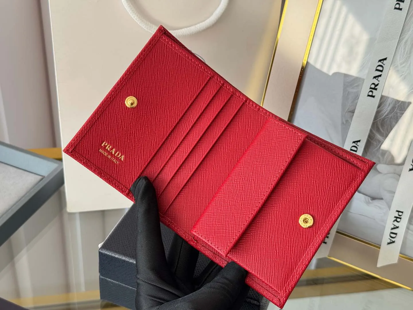 Prada women's two-fold short clip, with coin pocket and coin pocket. Model 1M0204, cross-grain cowhide. Size: 11.2x9.5cm. Simple and practical to enhance personal taste.