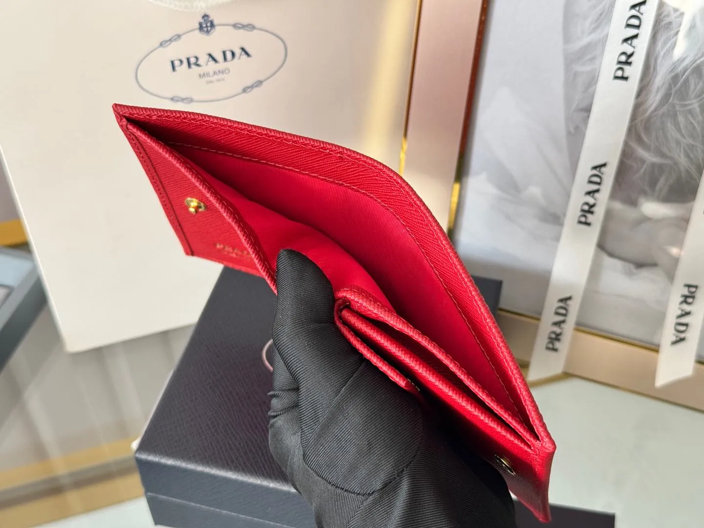 Prada women's two-fold short clip, with coin pocket and coin pocket. Model 1M0204, cross-grain cowhide. Size: 11.2x9.5cm. Simple and practical to enhance personal taste.