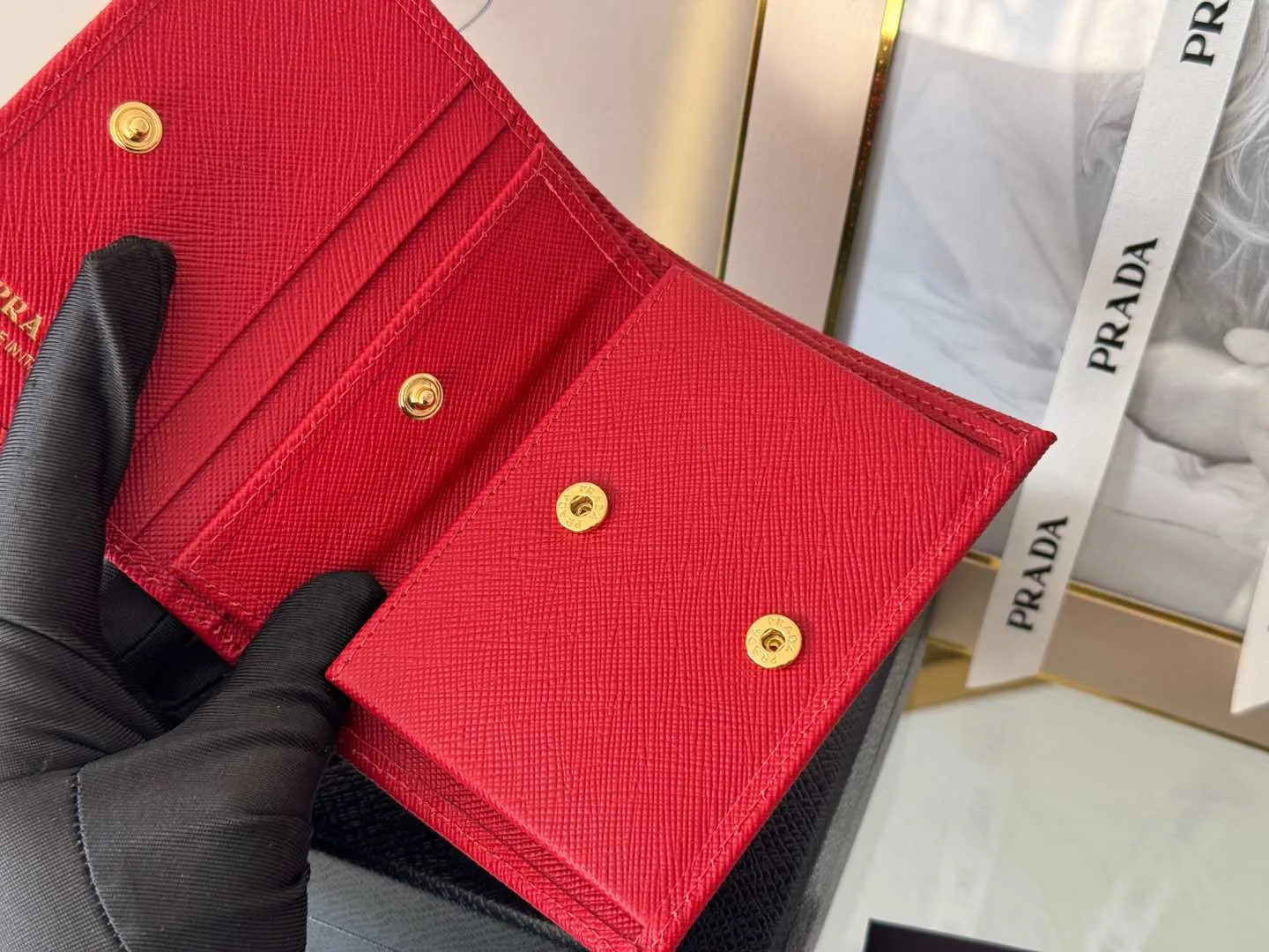 Prada women's two-fold short clip, with coin pocket and coin pocket. Model 1M0204, cross-grain cowhide. Size: 11.2x9.5cm. Simple and practical to enhance personal taste.