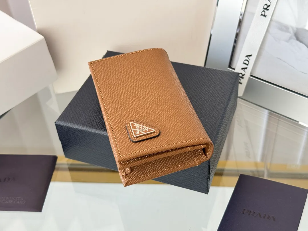 Prada classic card holder, model 1MC122, made of cross-grain cowhide, size 6.5×2.5×11cm, adopts snap button opening and closing design, and has two slots for cards or receipts. This exquisite card holder is small and convenient, with sufficient capacity. It can be placed in the bag for easy storage. It can also be used to make separate items when going out every day. Hot 🔥Hot-selling item, taken in kind, what you see is what you get