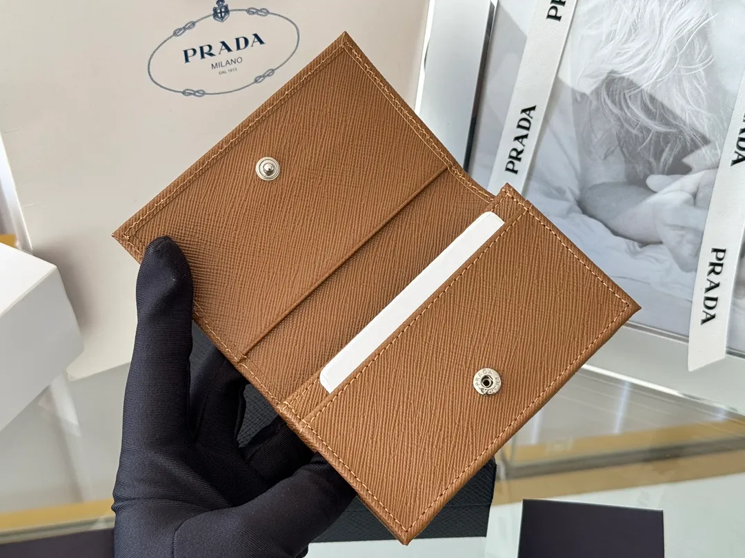 Prada classic card holder, model 1MC122, made of cross-grain cowhide, size 6.5×2.5×11cm, adopts snap button opening and closing design, and has two slots for cards or receipts. This exquisite card holder is small and convenient, with sufficient capacity. It can be placed in the bag for easy storage. It can also be used to make separate items when going out every day. Hot 🔥Hot-selling item, taken in kind, what you see is what you get
