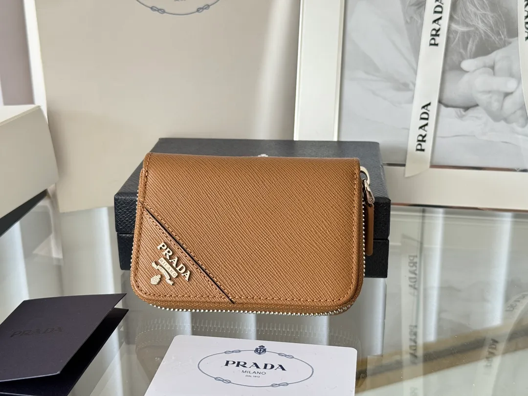 Prada Cross Pattern Unisex Card Holder Zipper Bag Model: 2MM358 Size: 10*8cm Original quality Color details are as shown in the picture, exclusive real shot Can be placed in the bag or held in hand Small and cute leather goods, made of cross pattern cowhide Classic and practical zipper design, with pleated card slots inside for easy classification and storage. It is perfect for going out alone with your mobile phone in summer or putting it in a small bag. It is your best choice.