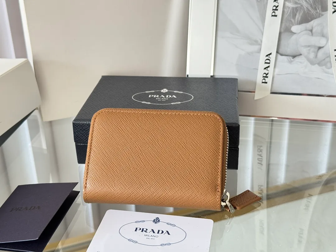 Prada Cross Pattern Unisex Card Holder Zipper Bag Model: 2MM358 Size: 10*8cm Original quality Color details are as shown in the picture, exclusive real shot Can be placed in the bag or held in hand Small and cute leather goods, made of cross pattern cowhide Classic and practical zipper design, with pleated card slots inside for easy classification and storage. It is perfect for going out alone with your mobile phone in summer or putting it in a small bag. It is your best choice.
