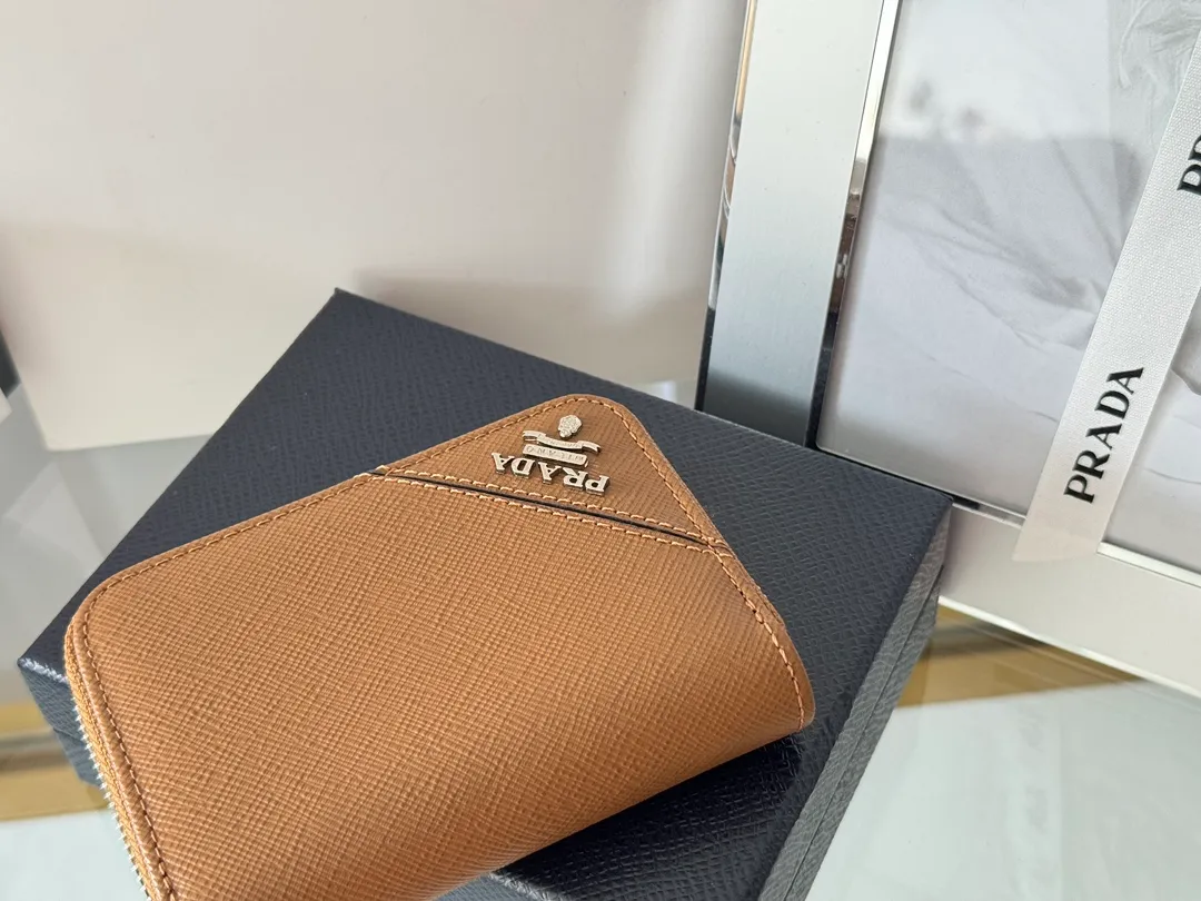 Prada Cross Pattern Unisex Card Holder Zipper Bag Model: 2MM358 Size: 10*8cm Original quality Color details are as shown in the picture, exclusive real shot Can be placed in the bag or held in hand Small and cute leather goods, made of cross pattern cowhide Classic and practical zipper design, with pleated card slots inside for easy classification and storage. It is perfect for going out alone with your mobile phone in summer or putting it in a small bag. It is your best choice.