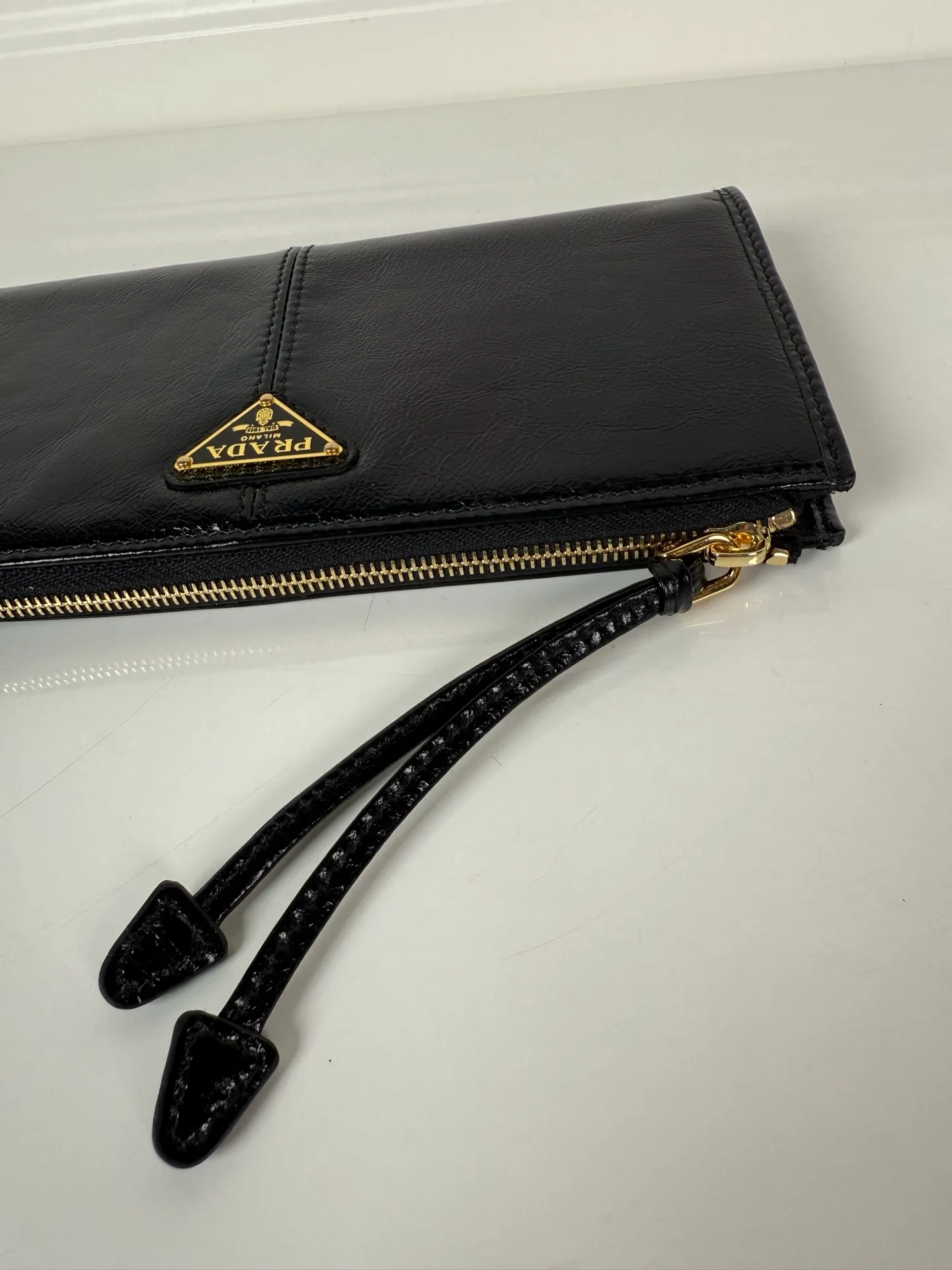 💰520, P Home ➡️Unisex pouch bag, this pouch is simple and exquisite, made of imported wax leather, with triangular metal logo and zipper closure. Model: 1MB051, size 20cm*10cm, 2 card slots, 1 leather lining