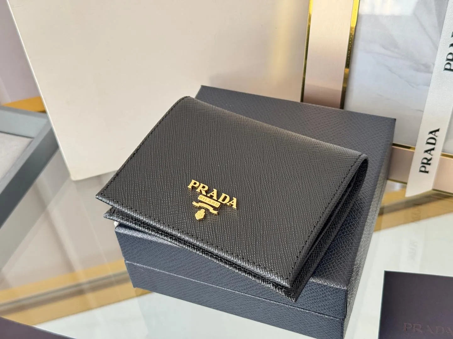 Prada women's two-fold short clip, with coin pocket and coin pocket. Model 1M0204, cross-grain cowhide. Size: 11.2x9.5cm. Simple and practical to enhance personal taste.
