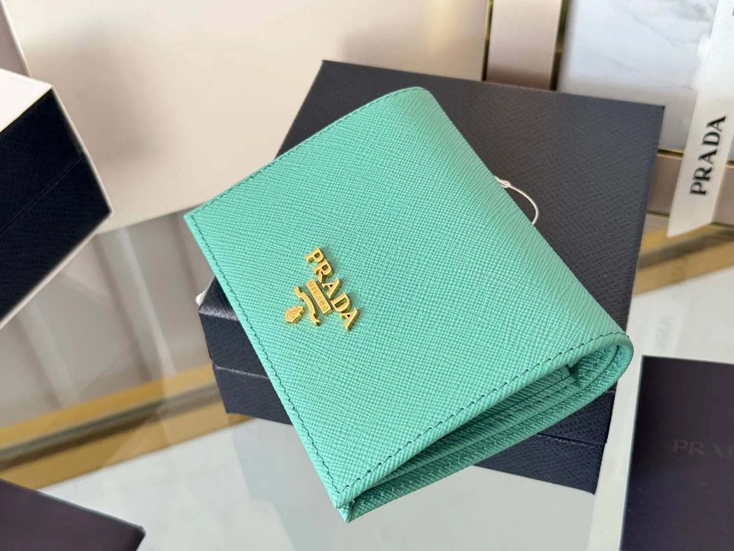 Prada women's two-fold short clip, with coin pocket and coin pocket. Model 1M0204, cross-grain cowhide. Size: 11.2x9.5cm. Simple and practical to enhance personal taste.