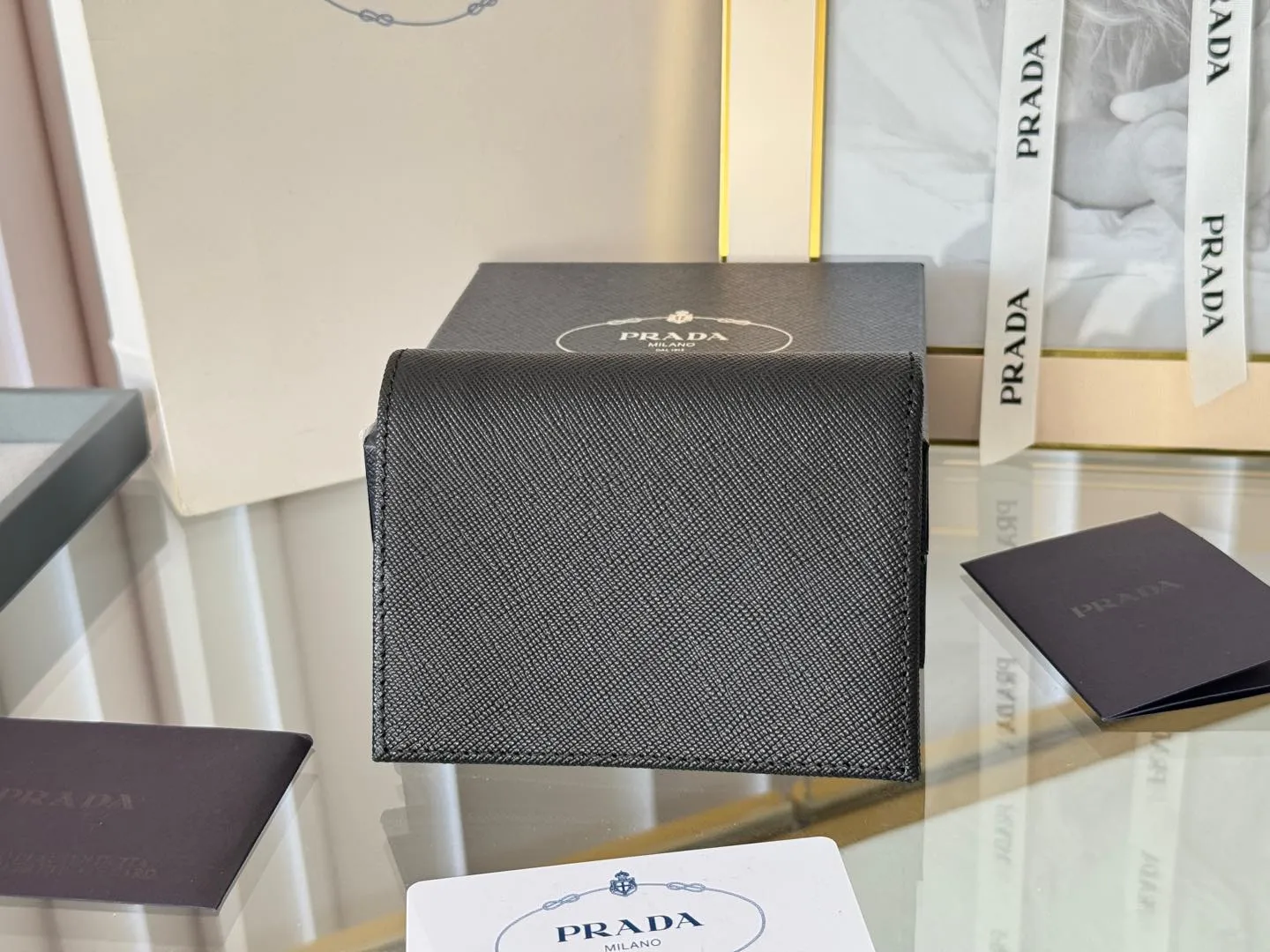 Prada women's two-fold short clip, with coin pocket and coin pocket. Model 1M0204, cross-grain cowhide. Size: 11.2x9.5cm. Simple and practical to enhance personal taste.