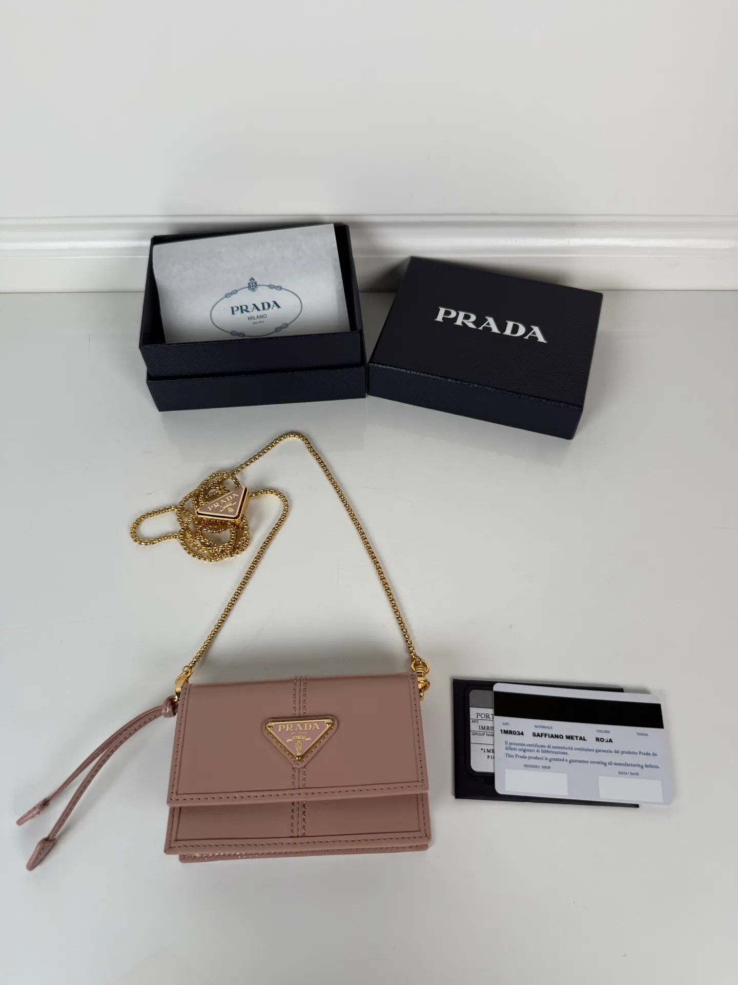 💰900; P Home ➡️Multifunctional mini backpack for women, model 1MR034, flip-top card holder with detachable Saffiano leather shoulder strap, metal triangular micro-mark decorating the front, size 11.5 x8 x2.5cm, two card slots inside, snap closure, in summer it is a mini backpack, in winter it can be turned into a small card holder by removing the shoulder strap, super practical and worth owning👍