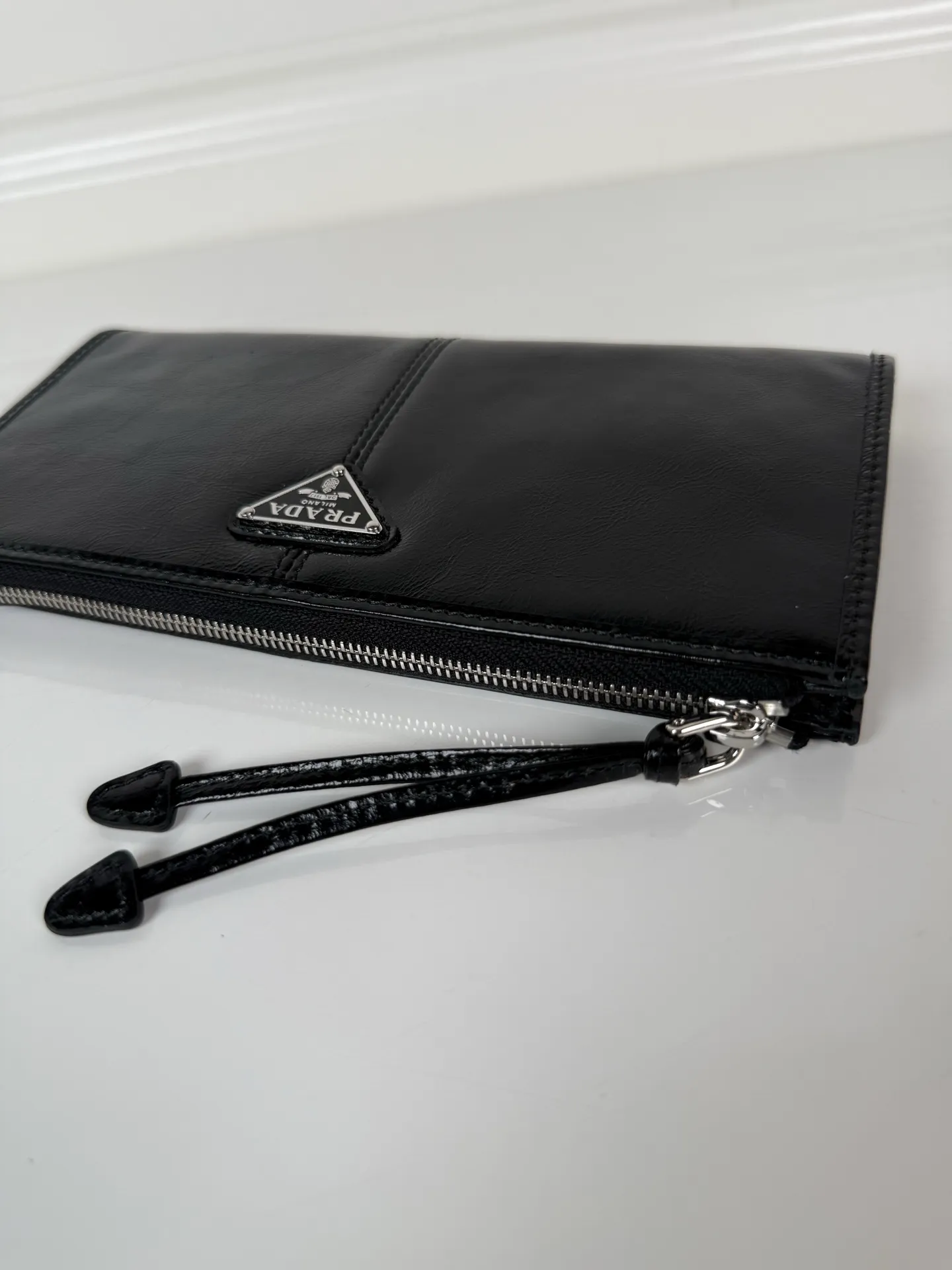 💰520, P Home ➡️Unisex pouch bag, this pouch is simple and exquisite, made of imported wax leather, with triangular metal logo and zipper closure. Model: 1MB051, size 20cm*10cm, 2 card slots, 1 leather lining