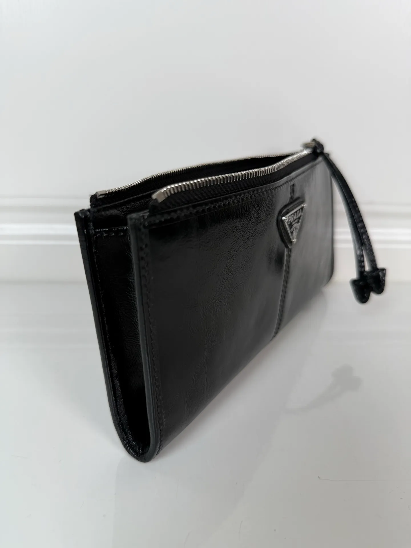 💰520, P Home ➡️Unisex pouch bag, this pouch is simple and exquisite, made of imported wax leather, with triangular metal logo and zipper closure. Model: 1MB051, size 20cm*10cm, 2 card slots, 1 leather lining