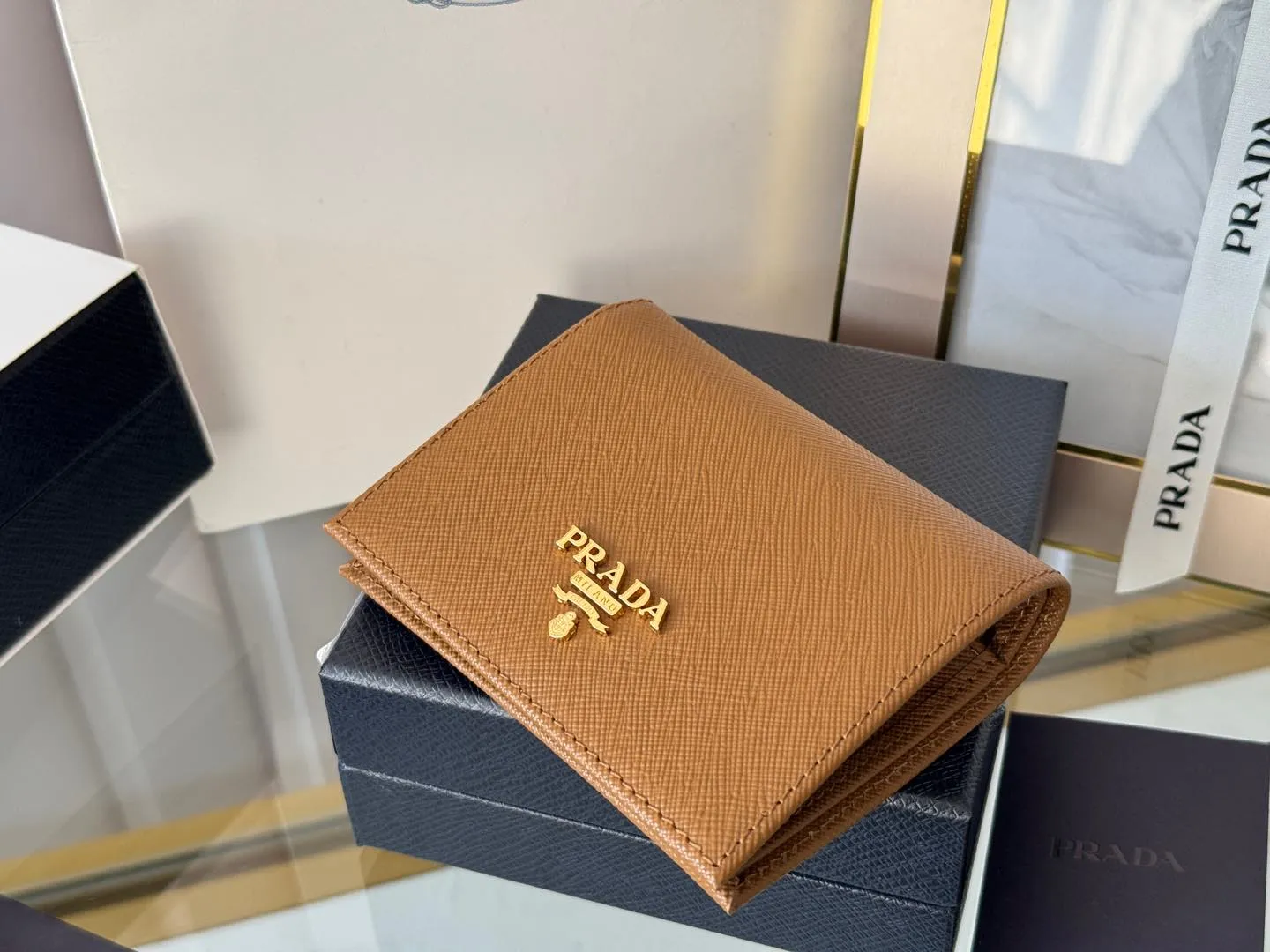 Prada women's two-fold short clip, with coin pocket and coin pocket. Model 1M0204, cross-grain cowhide. Size: 11.2x9.5cm. Simple and practical to enhance personal taste.