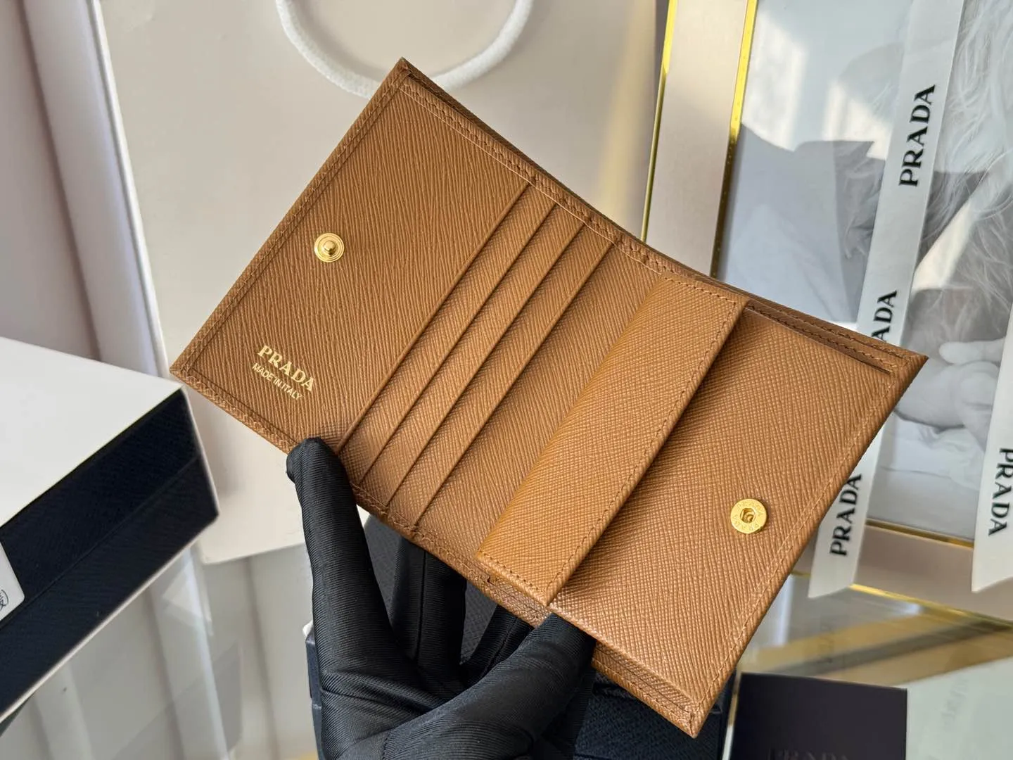 Prada women's two-fold short clip, with coin pocket and coin pocket. Model 1M0204, cross-grain cowhide. Size: 11.2x9.5cm. Simple and practical to enhance personal taste.