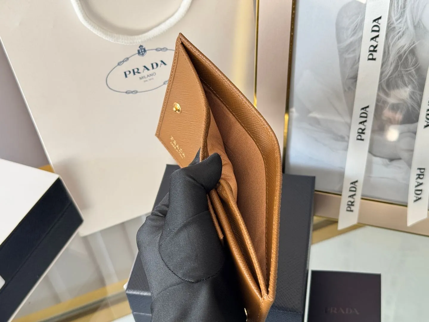 Prada women's two-fold short clip, with coin pocket and coin pocket. Model 1M0204, cross-grain cowhide. Size: 11.2x9.5cm. Simple and practical to enhance personal taste.