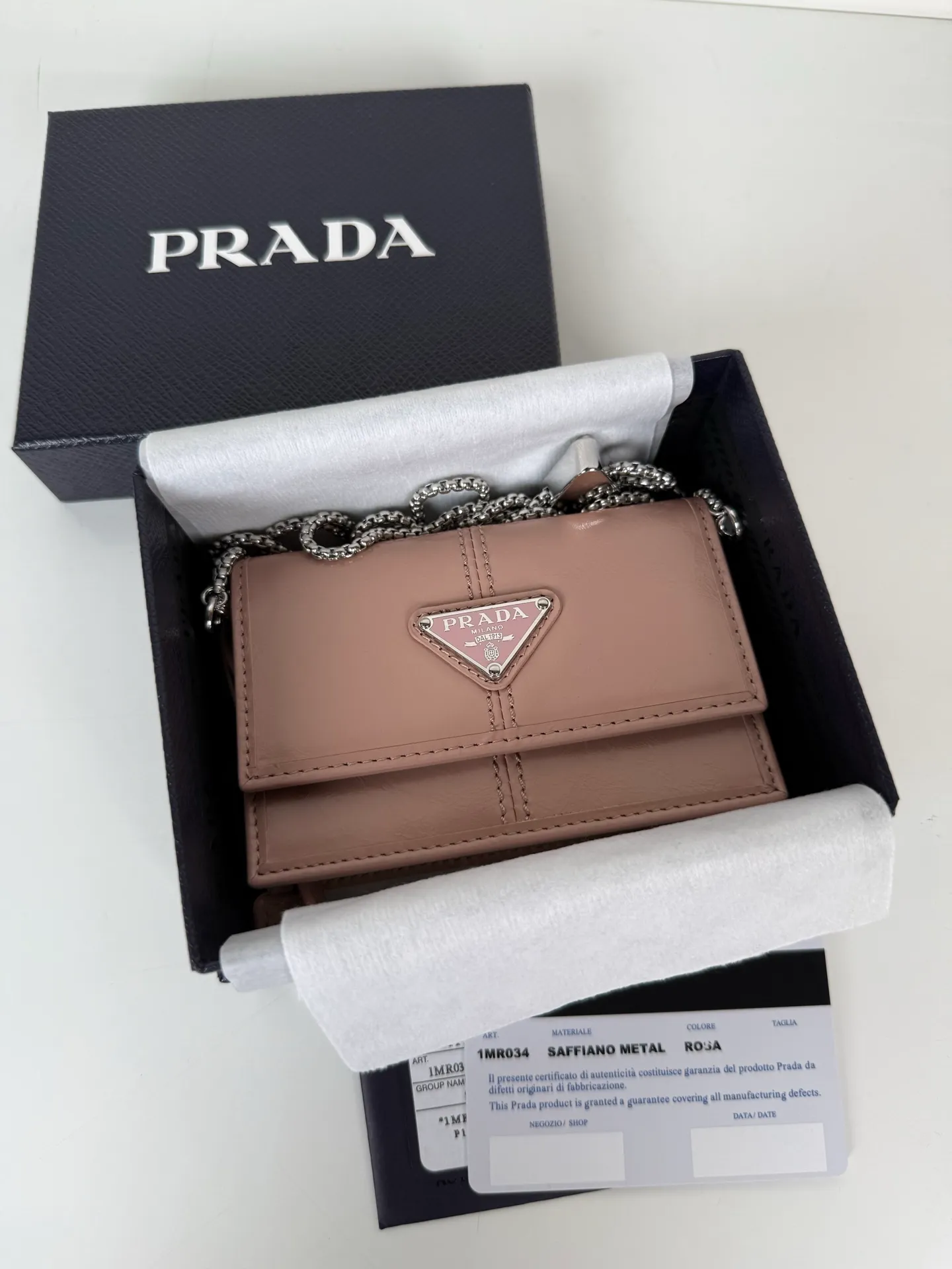 💰900; P Home ➡️Multifunctional mini backpack for women, model 1MR034, flip-top card holder with detachable Saffiano leather shoulder strap, metal triangular micro-mark decorating the front, size 11.5 x8 x2.5cm, two card slots inside, snap closure, in summer it is a mini backpack, in winter it can be turned into a small card holder by removing the shoulder strap, super practical and worth owning👍