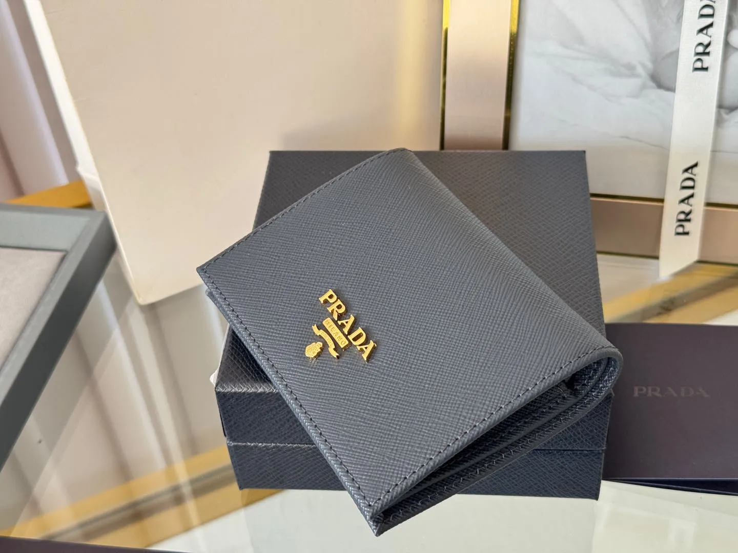 Prada women's two-fold short clip, with coin pocket and coin pocket. Model 1M0204, cross-grain cowhide. Size: 11.2x9.5cm. Simple and practical to enhance personal taste.