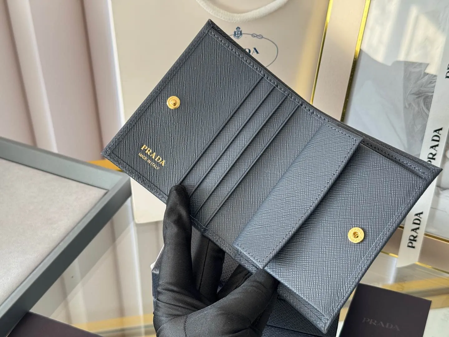 Prada women's two-fold short clip, with coin pocket and coin pocket. Model 1M0204, cross-grain cowhide. Size: 11.2x9.5cm. Simple and practical to enhance personal taste.
