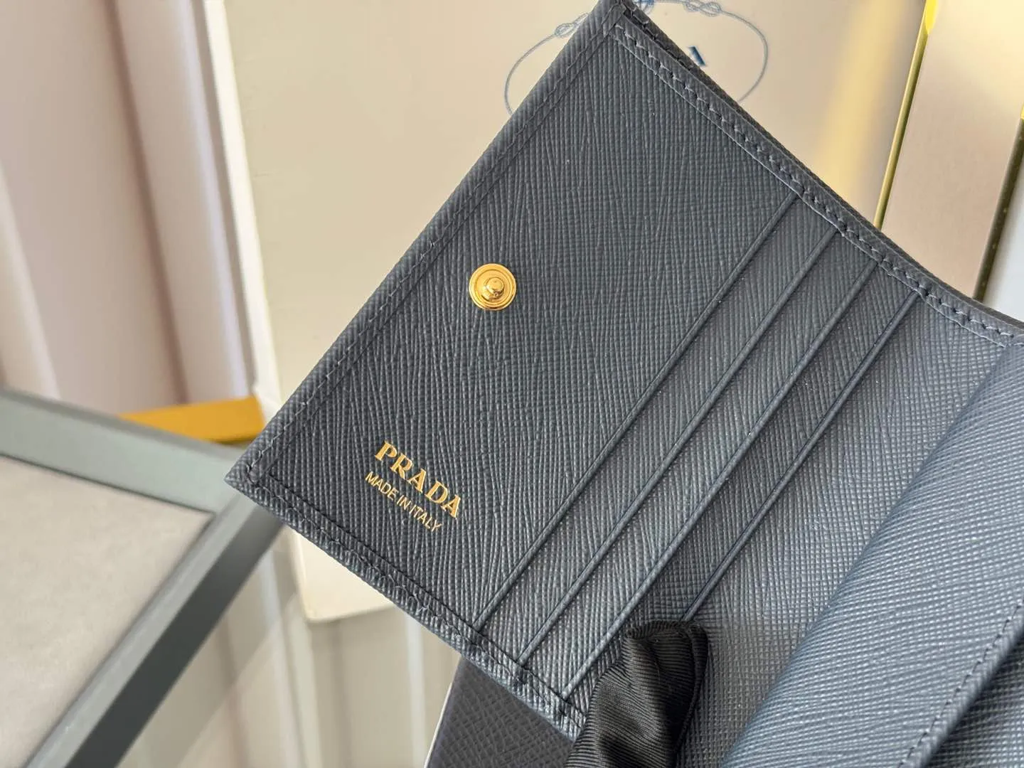 Prada women's two-fold short clip, with coin pocket and coin pocket. Model 1M0204, cross-grain cowhide. Size: 11.2x9.5cm. Simple and practical to enhance personal taste.