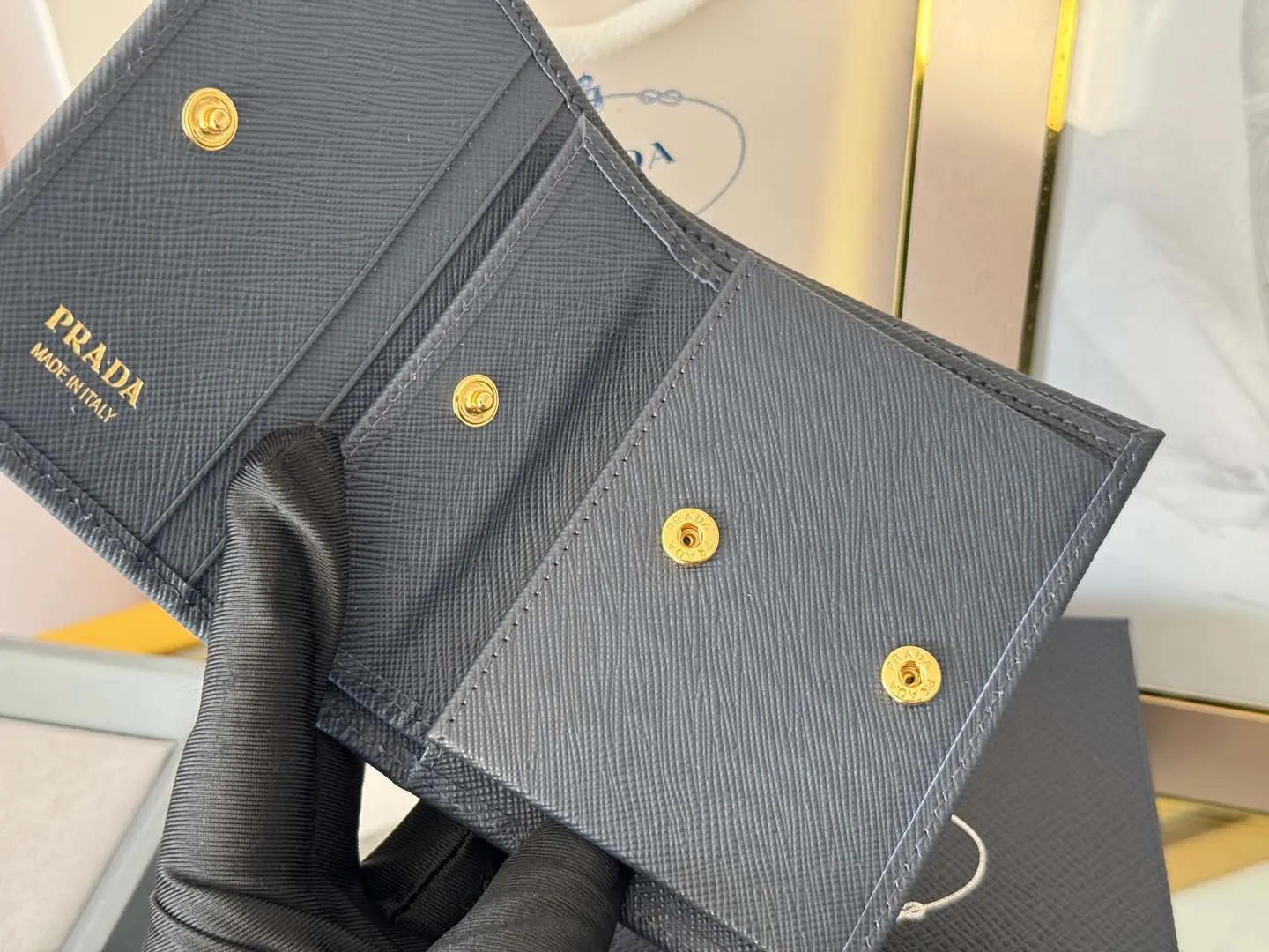 Prada women's two-fold short clip, with coin pocket and coin pocket. Model 1M0204, cross-grain cowhide. Size: 11.2x9.5cm. Simple and practical to enhance personal taste.