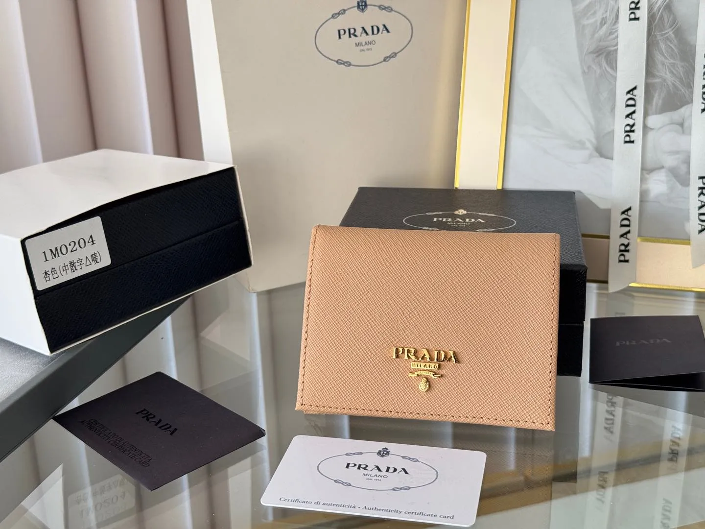 Prada women's two-fold short clip, with coin pocket and coin pocket. Model 1M0204, cross-grain cowhide. Size: 11.2x9.5cm. Simple and practical to enhance personal taste.