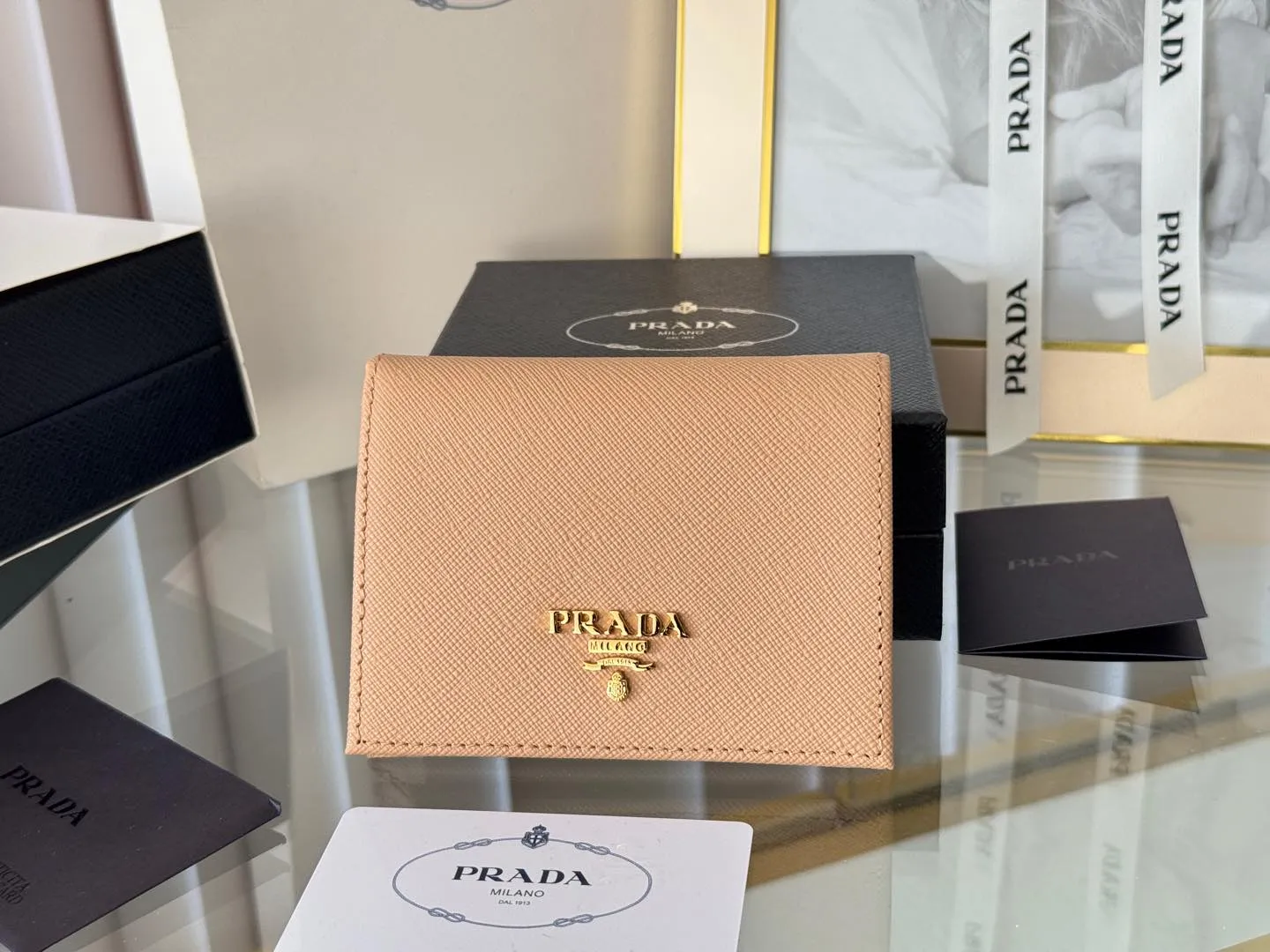 Prada women's two-fold short clip, with coin pocket and coin pocket. Model 1M0204, cross-grain cowhide. Size: 11.2x9.5cm. Simple and practical to enhance personal taste.