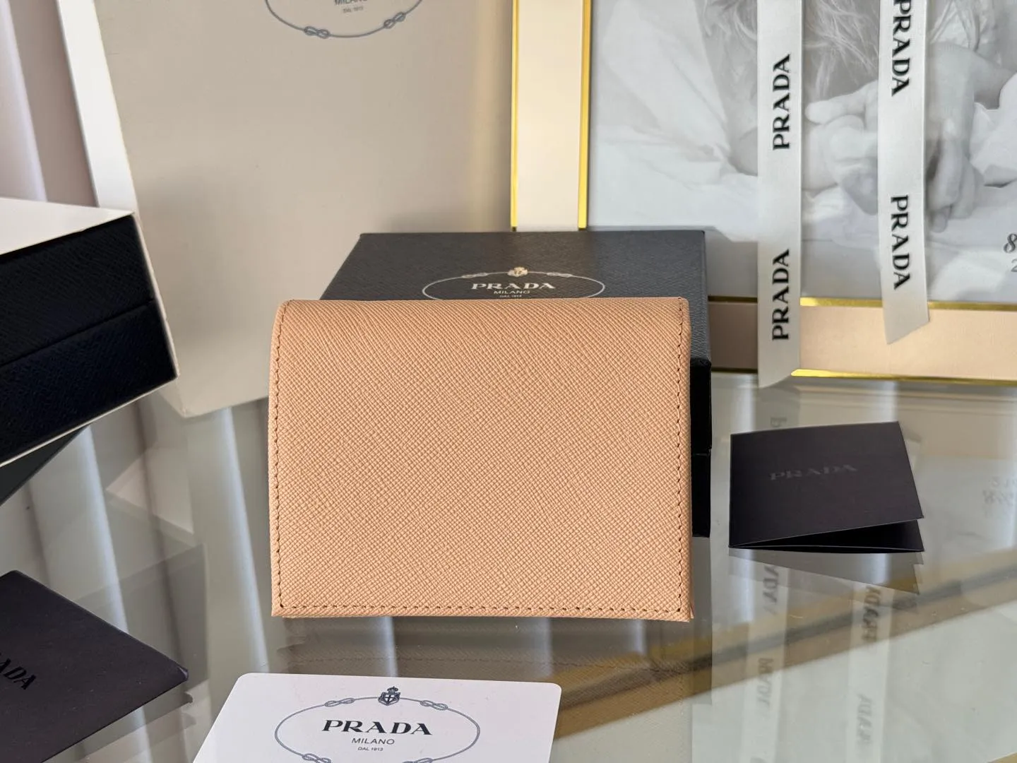 Prada women's two-fold short clip, with coin pocket and coin pocket. Model 1M0204, cross-grain cowhide. Size: 11.2x9.5cm. Simple and practical to enhance personal taste.