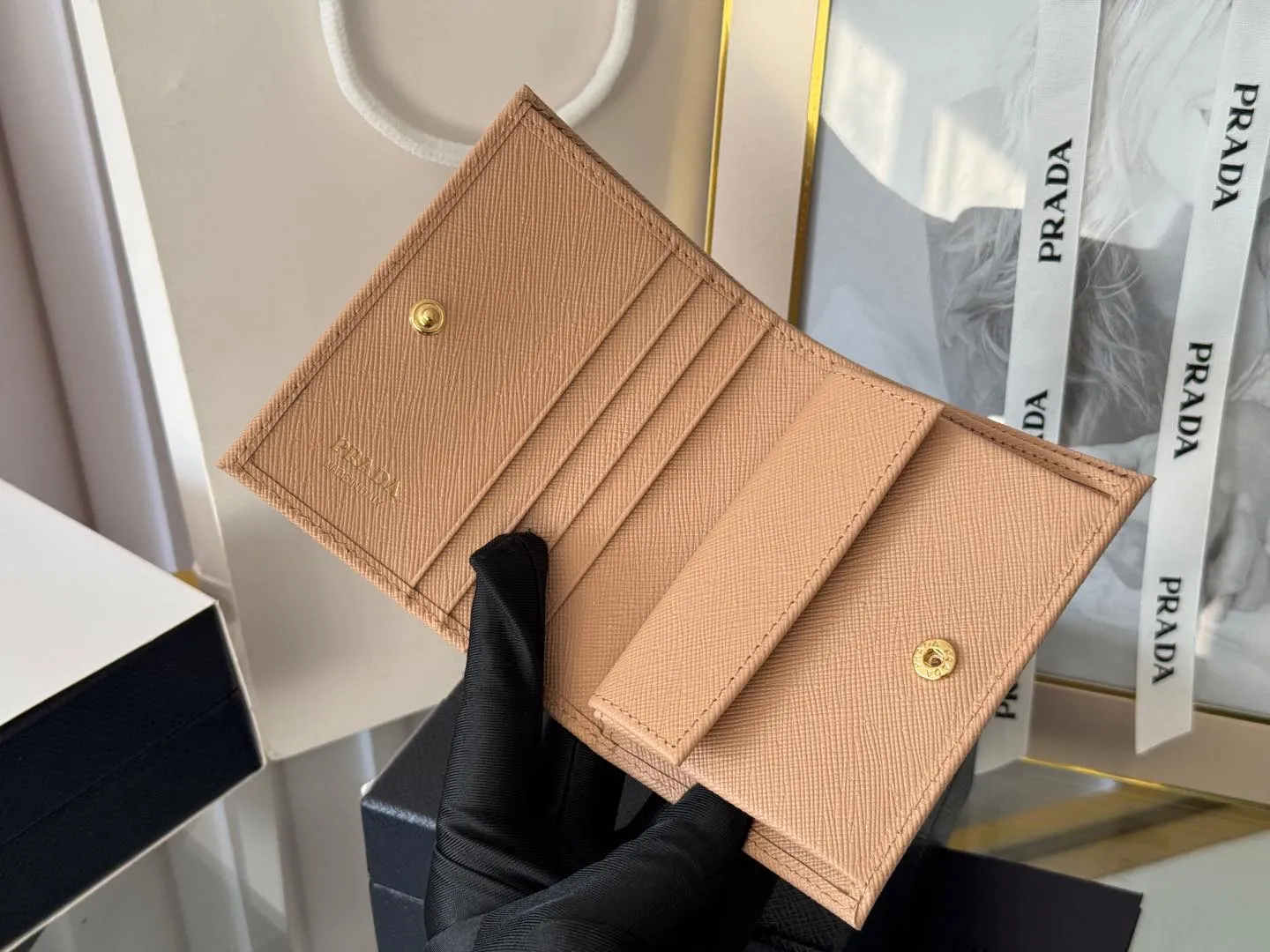 Prada women's two-fold short clip, with coin pocket and coin pocket. Model 1M0204, cross-grain cowhide. Size: 11.2x9.5cm. Simple and practical to enhance personal taste.