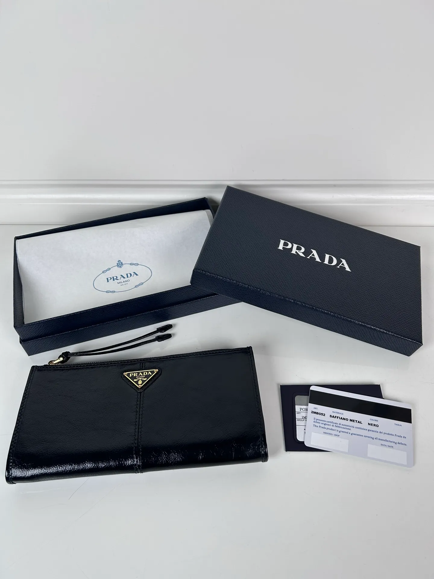 💰520, P Home ➡️Unisex pouch bag, this pouch is simple and exquisite, made of imported wax leather, with triangular metal logo and zipper closure. Model: 1MB051, size 20cm*10cm, 2 card slots, 1 leather lining