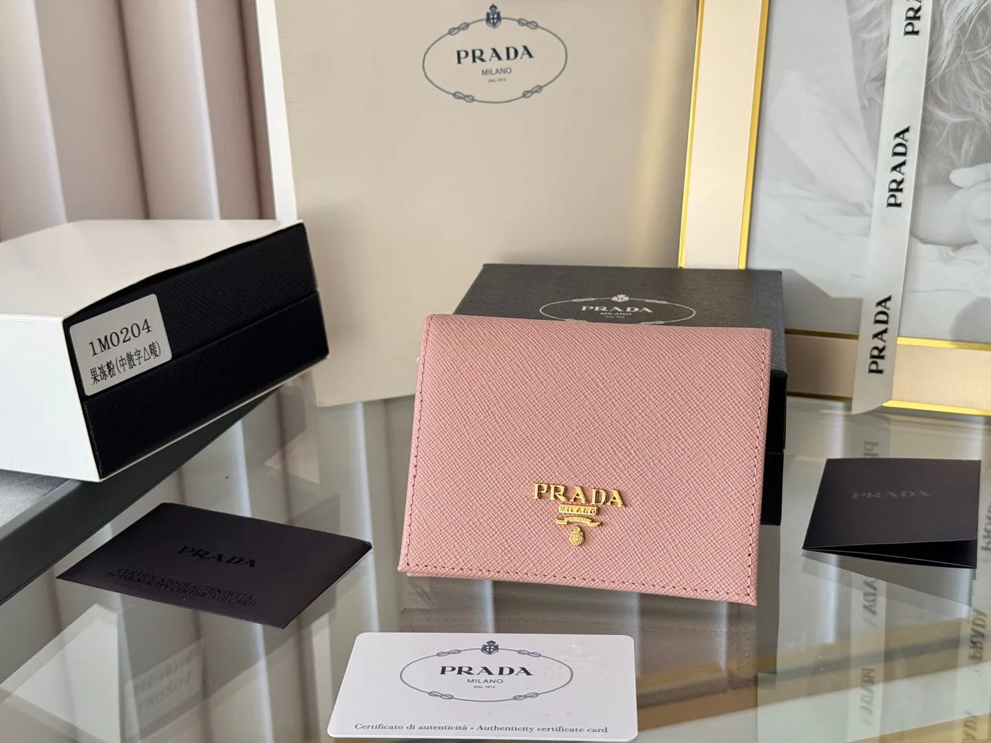 Prada women's two-fold short clip, with coin pocket and coin pocket. Model 1M0204, cross-grain cowhide. Size: 11.2x9.5cm. Simple and practical to enhance personal taste.
