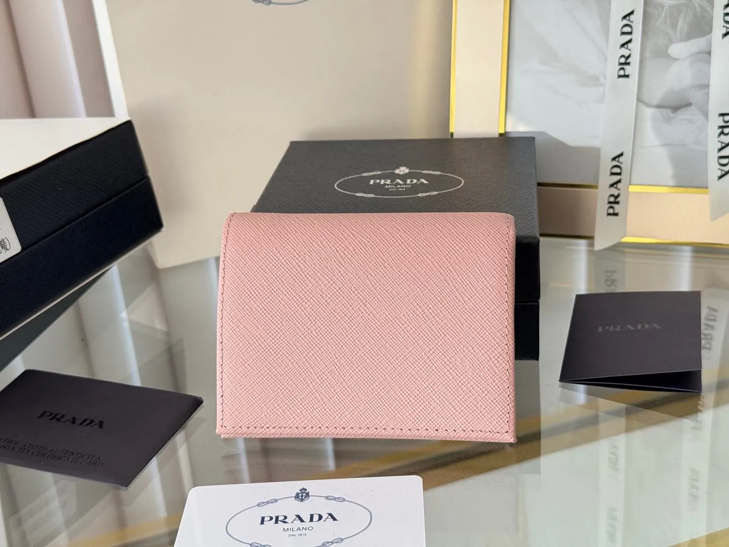 Prada women's two-fold short clip, with coin pocket and coin pocket. Model 1M0204, cross-grain cowhide. Size: 11.2x9.5cm. Simple and practical to enhance personal taste.