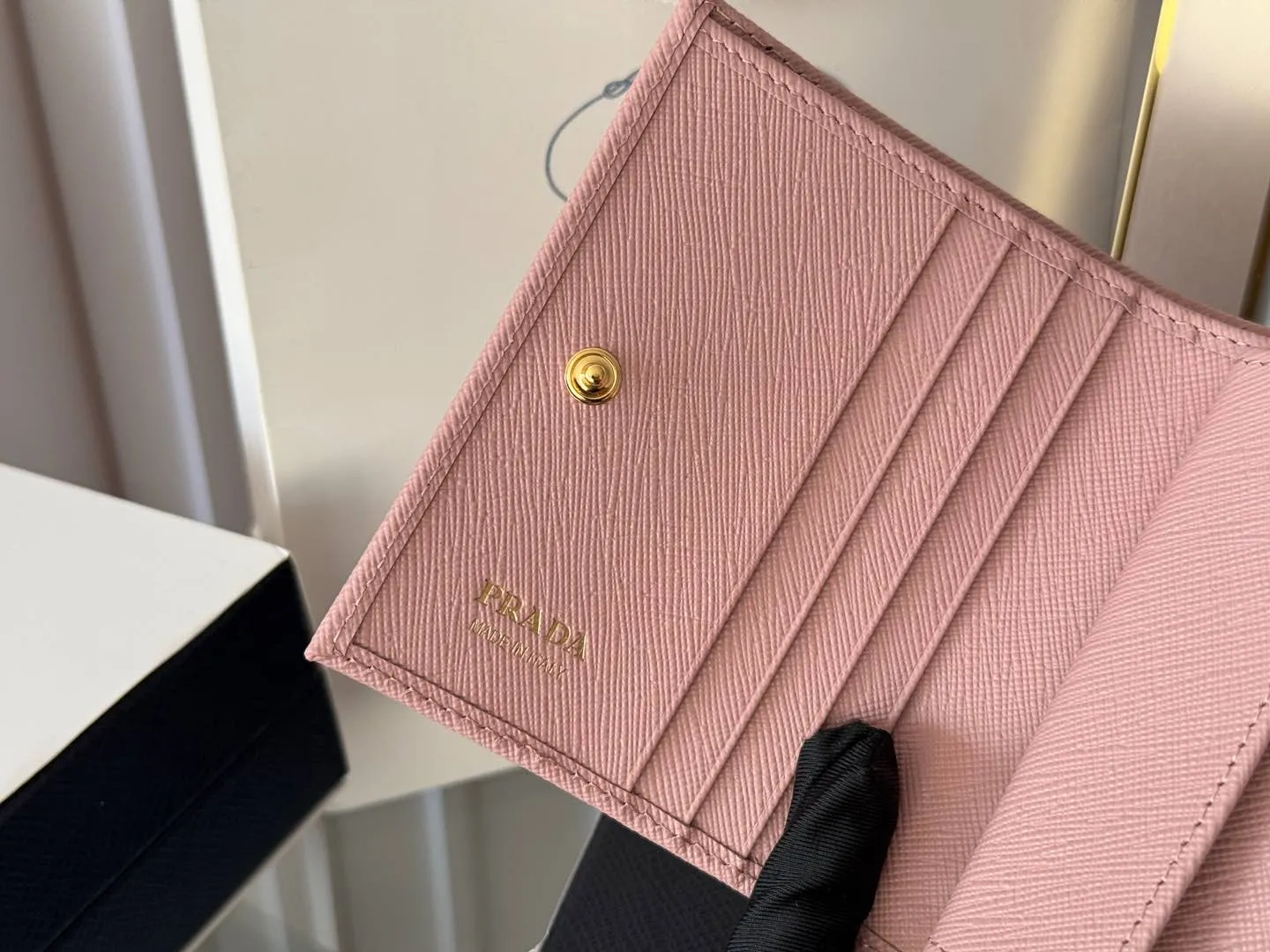 Prada women's two-fold short clip, with coin pocket and coin pocket. Model 1M0204, cross-grain cowhide. Size: 11.2x9.5cm. Simple and practical to enhance personal taste.