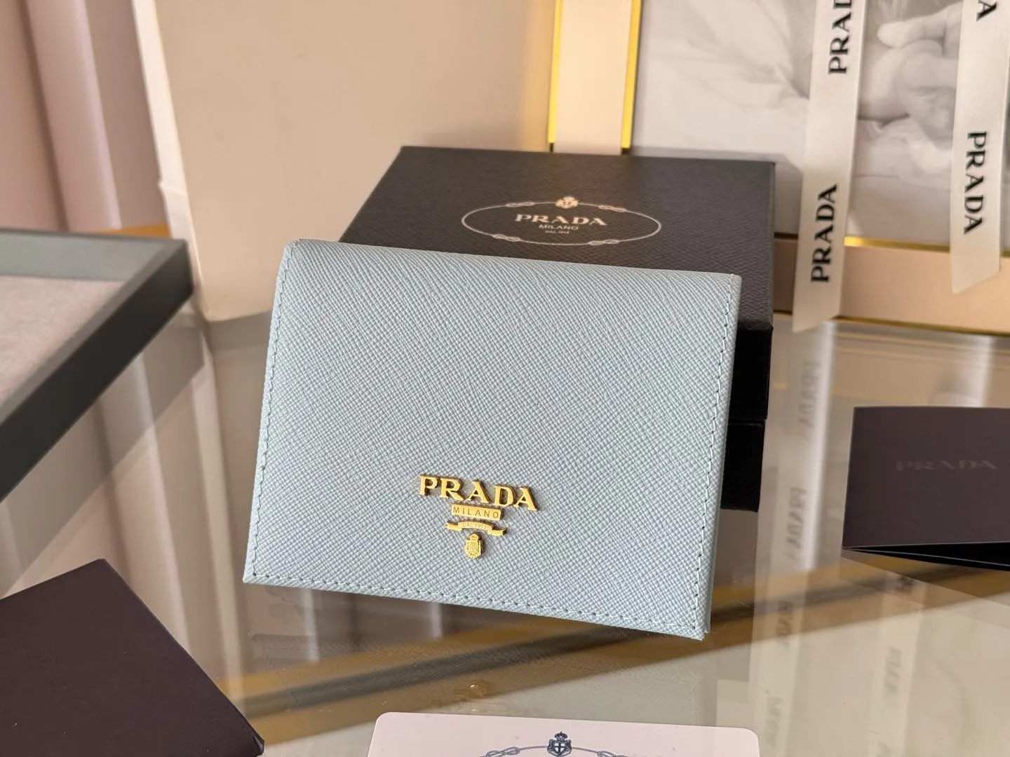 Prada women's two-fold short clip, with coin pocket and coin pocket. Model 1M0204, cross-grain cowhide. Size: 11.2x9.5cm. Simple and practical to enhance personal taste.