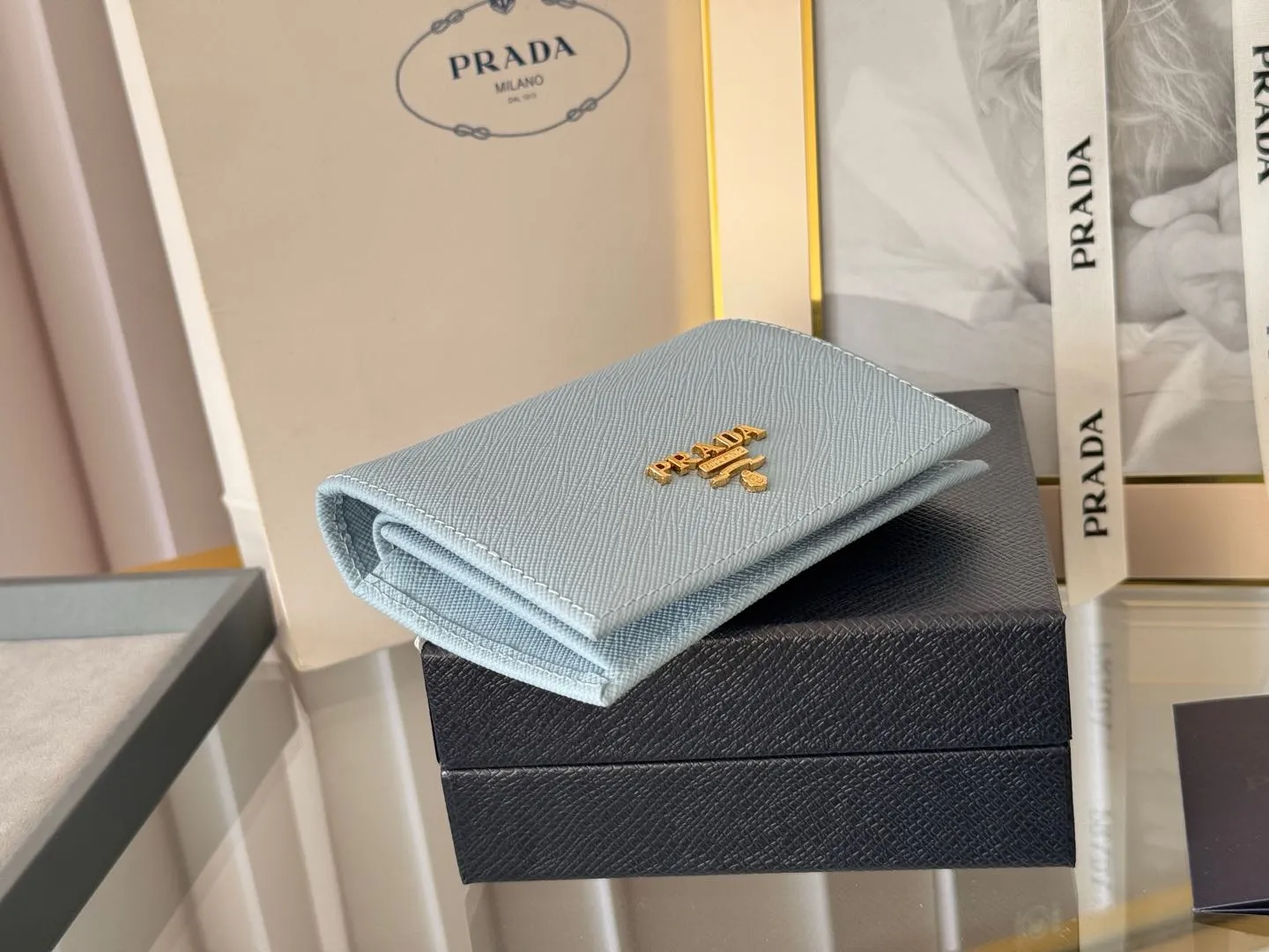 Prada women's two-fold short clip, with coin pocket and coin pocket. Model 1M0204, cross-grain cowhide. Size: 11.2x9.5cm. Simple and practical to enhance personal taste.