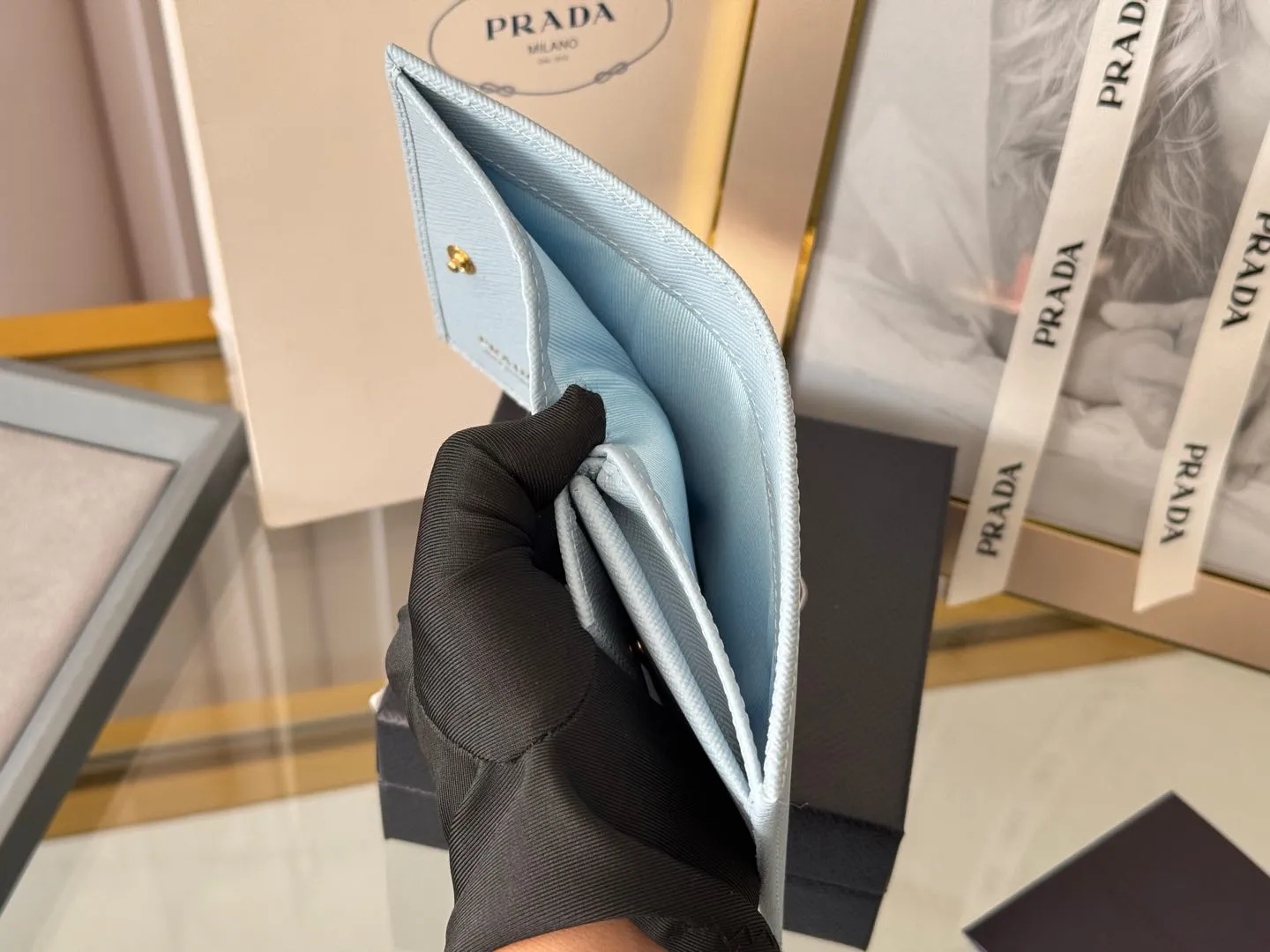 Prada women's two-fold short clip, with coin pocket and coin pocket. Model 1M0204, cross-grain cowhide. Size: 11.2x9.5cm. Simple and practical to enhance personal taste.