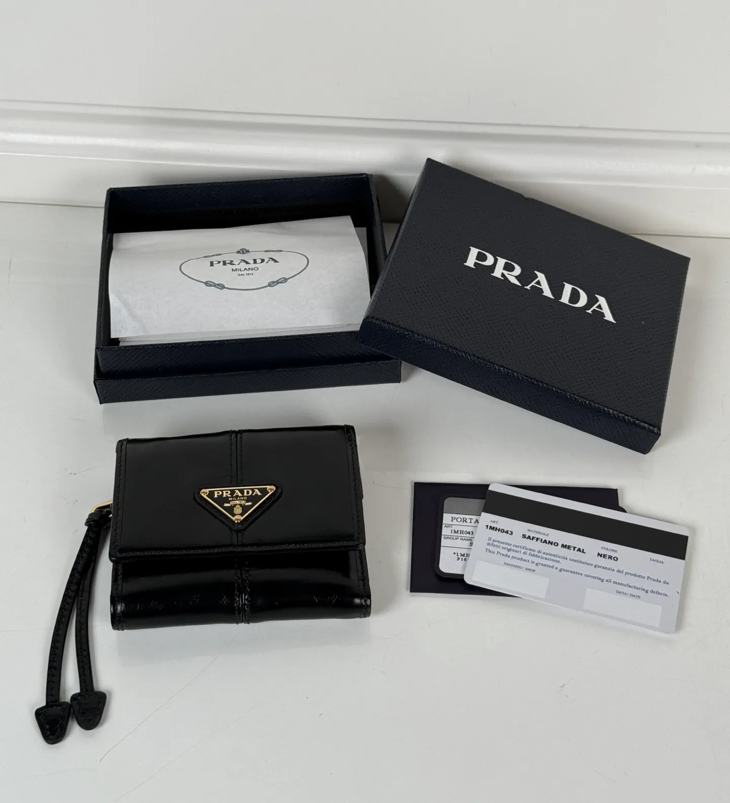 💰480, P Home ➡️Women's black waxed leather short clip, original quality, model 1MH043, four card slots, one receipt compartment, two ID pockets, one external pocket, one internal flip-top coin pocket, size 10x8.5cm.