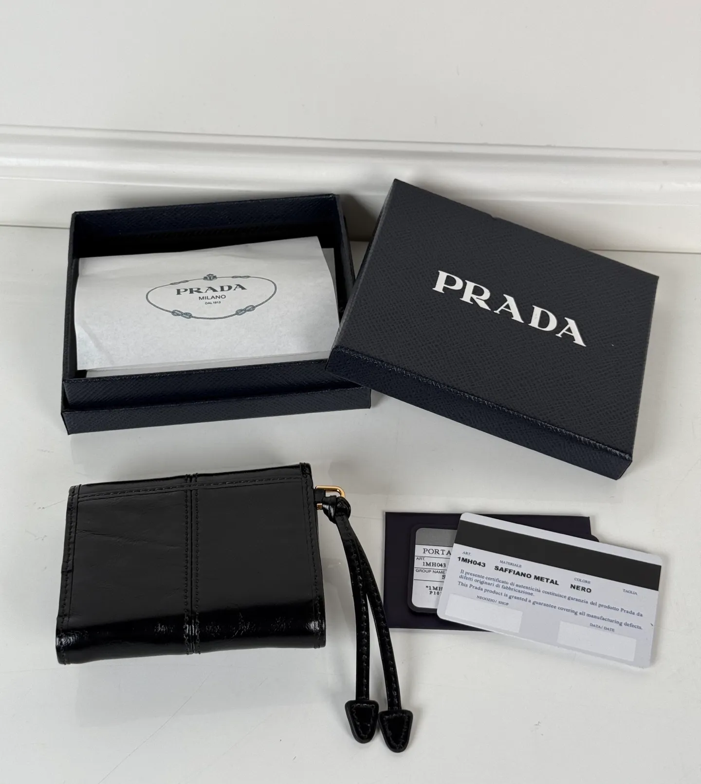 💰480, P Home ➡️Women's black waxed leather short clip, original quality, model 1MH043, four card slots, one receipt compartment, two ID pockets, one external pocket, one internal flip-top coin pocket, size 10x8.5cm.