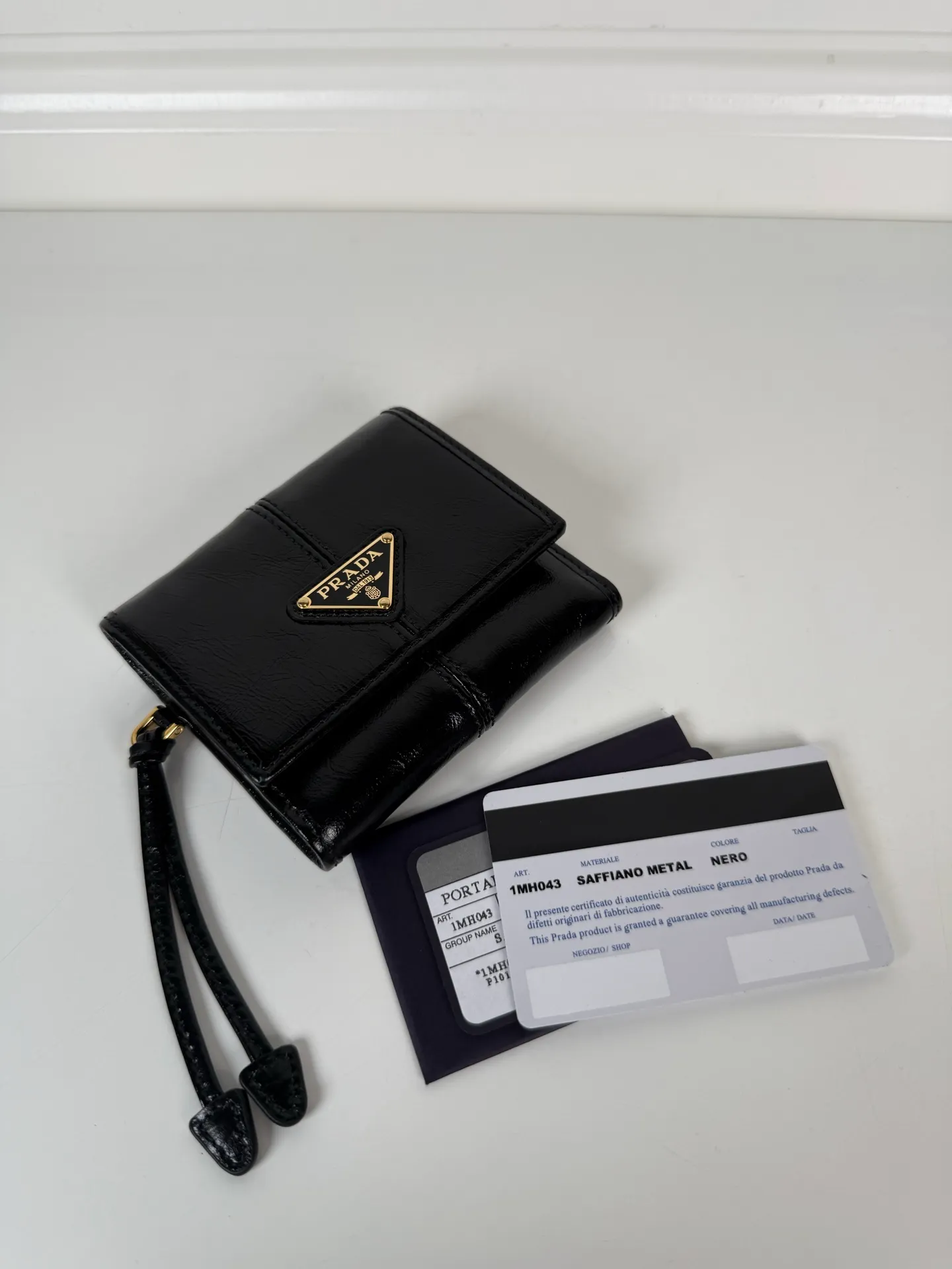 💰480, P Home ➡️Women's black waxed leather short clip, original quality, model 1MH043, four card slots, one receipt compartment, two ID pockets, one external pocket, one internal flip-top coin pocket, size 10x8.5cm.