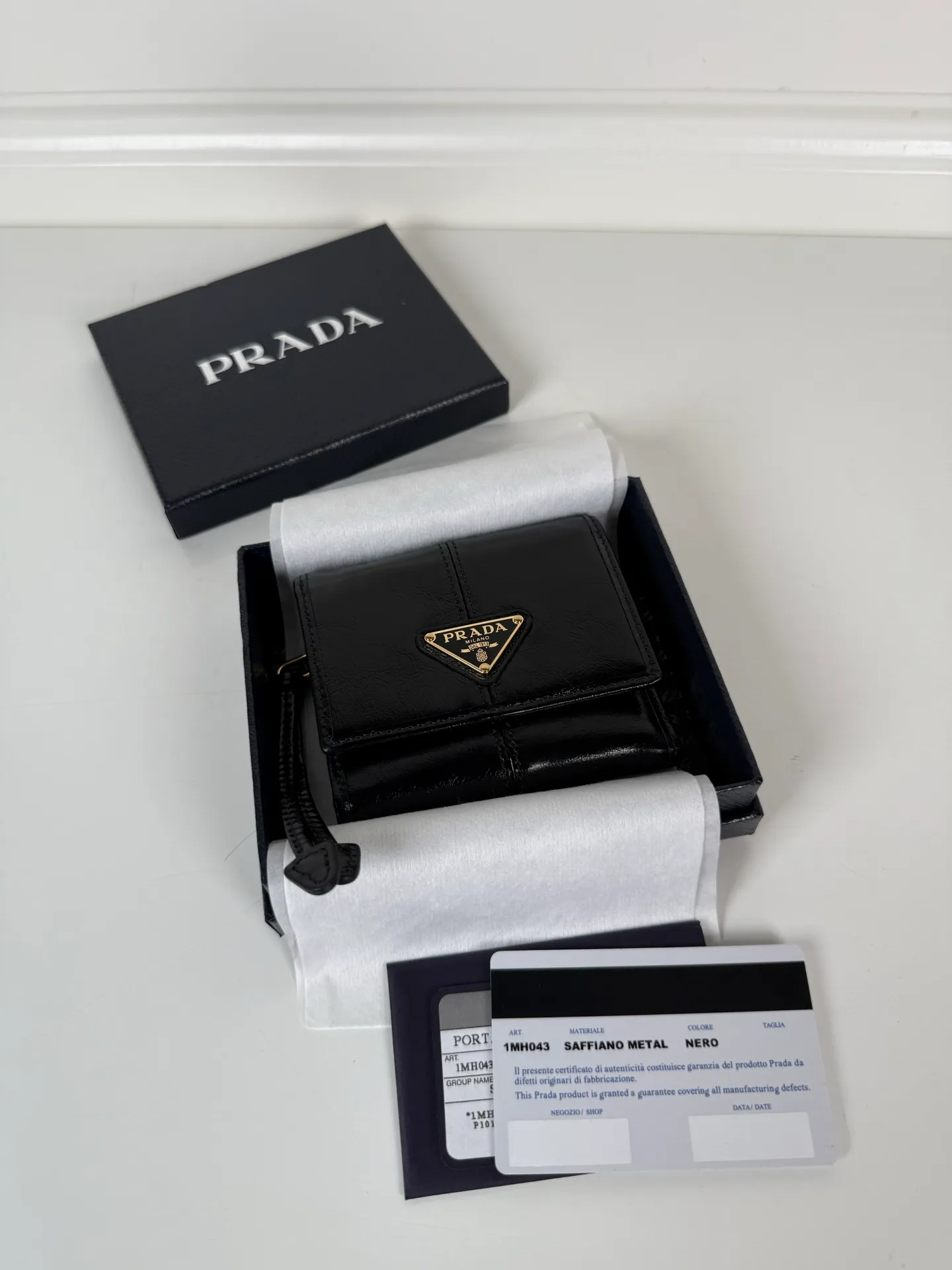 💰480, P Home ➡️Women's black waxed leather short clip, original quality, model 1MH043, four card slots, one receipt compartment, two ID pockets, one external pocket, one internal flip-top coin pocket, size 10x8.5cm.